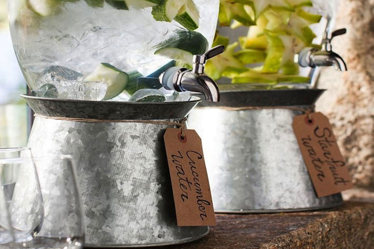 A water dispenser with cucumber slices and ice.