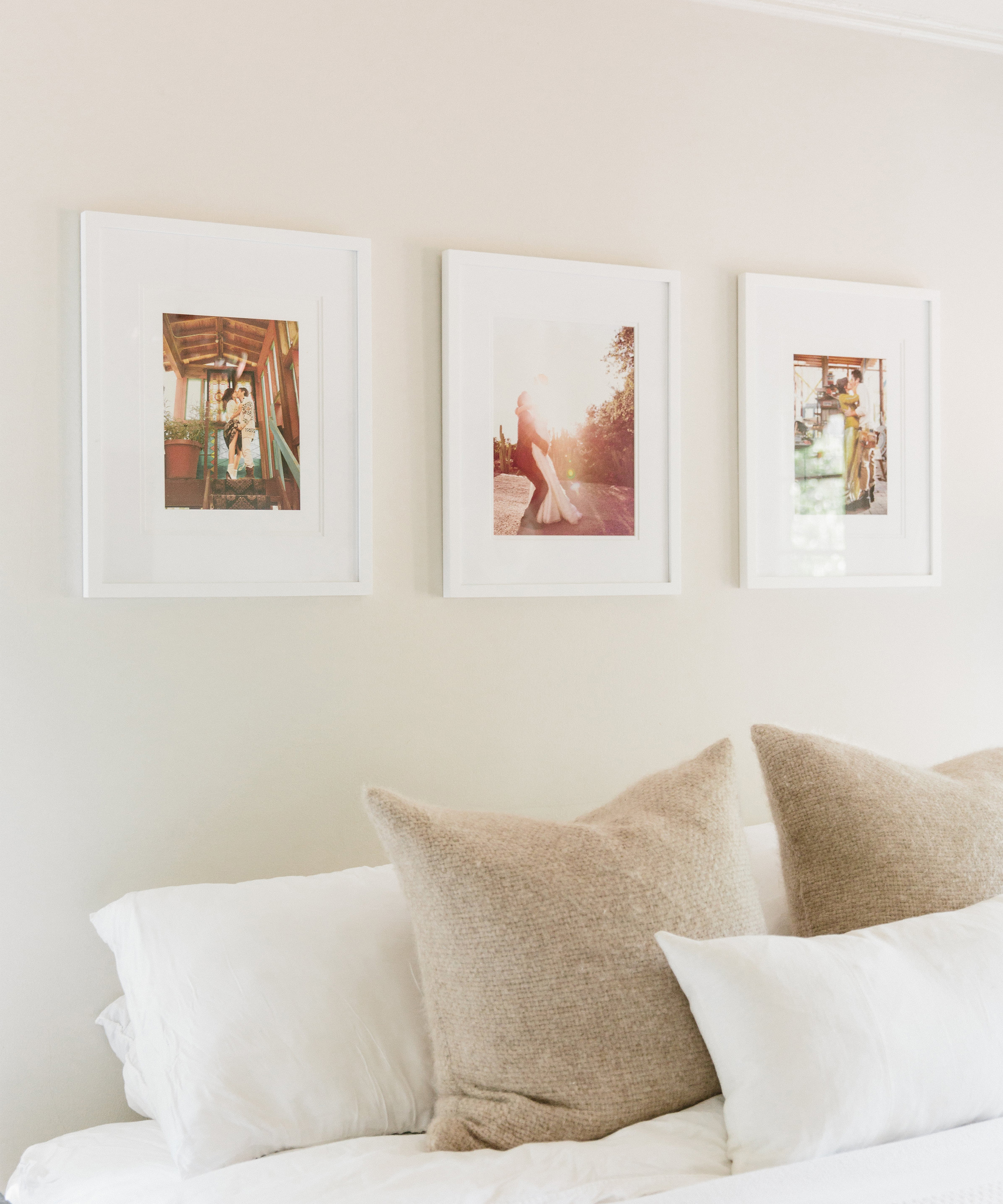 Corner of Odette Annable's bed with three framed photographs on the wall and Jenni Kayne pillows on bed
