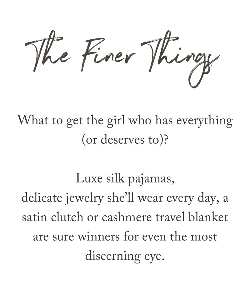 Text reads: The Finer Things. Our holiday gift guide features luxe silk pajamas, delicate jewelry she’ll wear every day, a satin clutch or cashmere travel blanket—sure winners for even the most discerning eye (or the girl who has everything).
