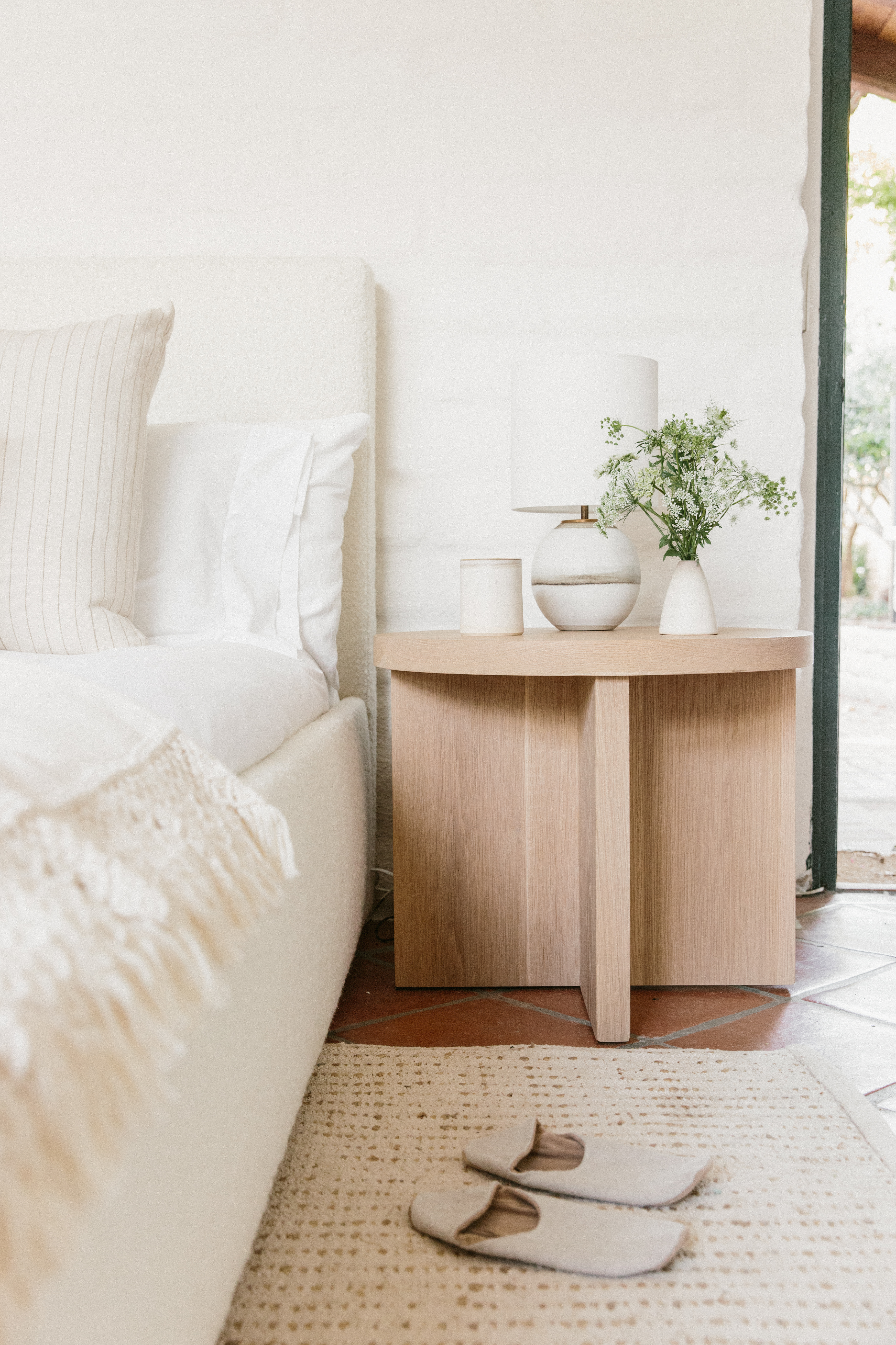 Wooden bedside table with a bouquet of flowers on it.
