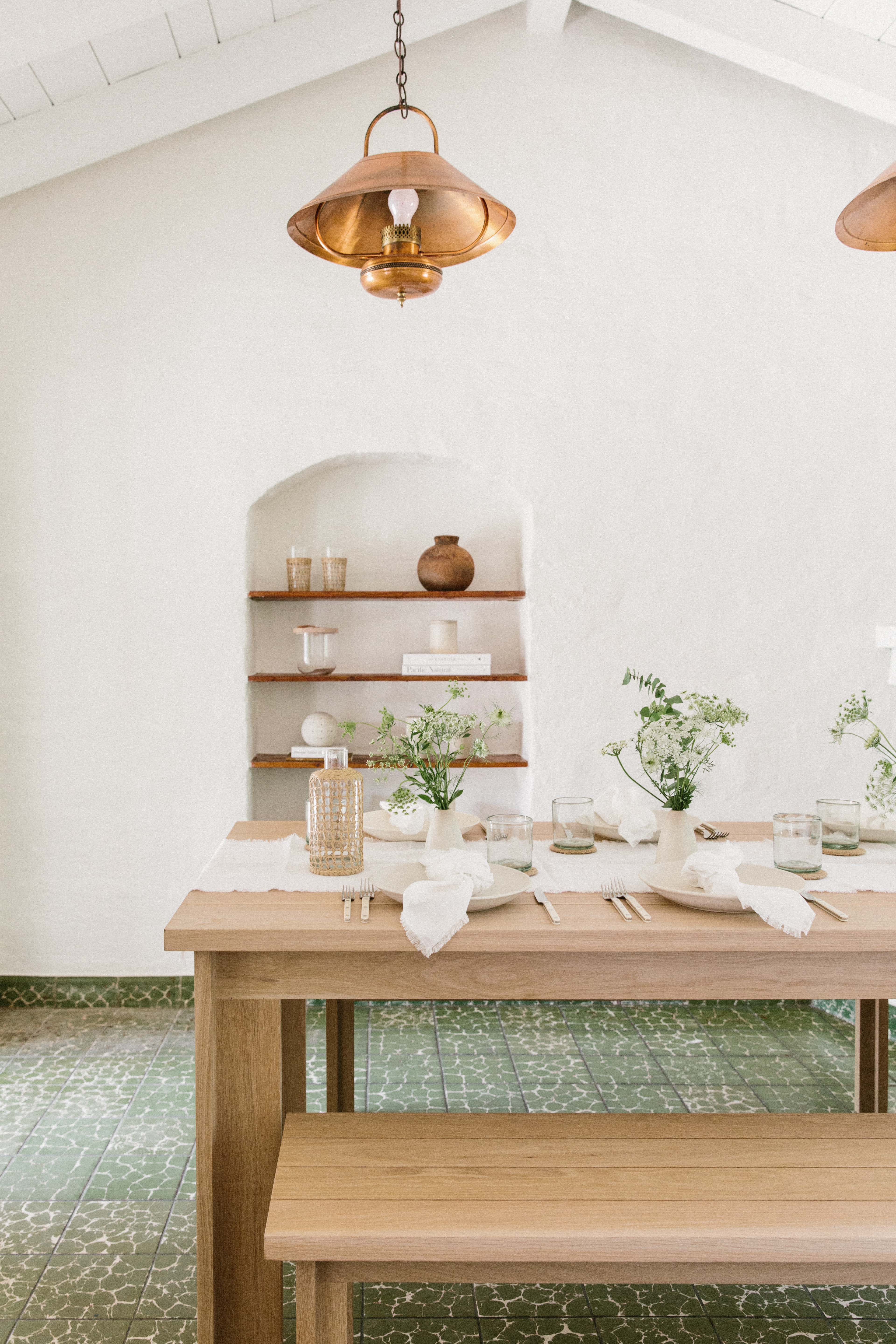 Wooden table and bench with flowers and decor on it.