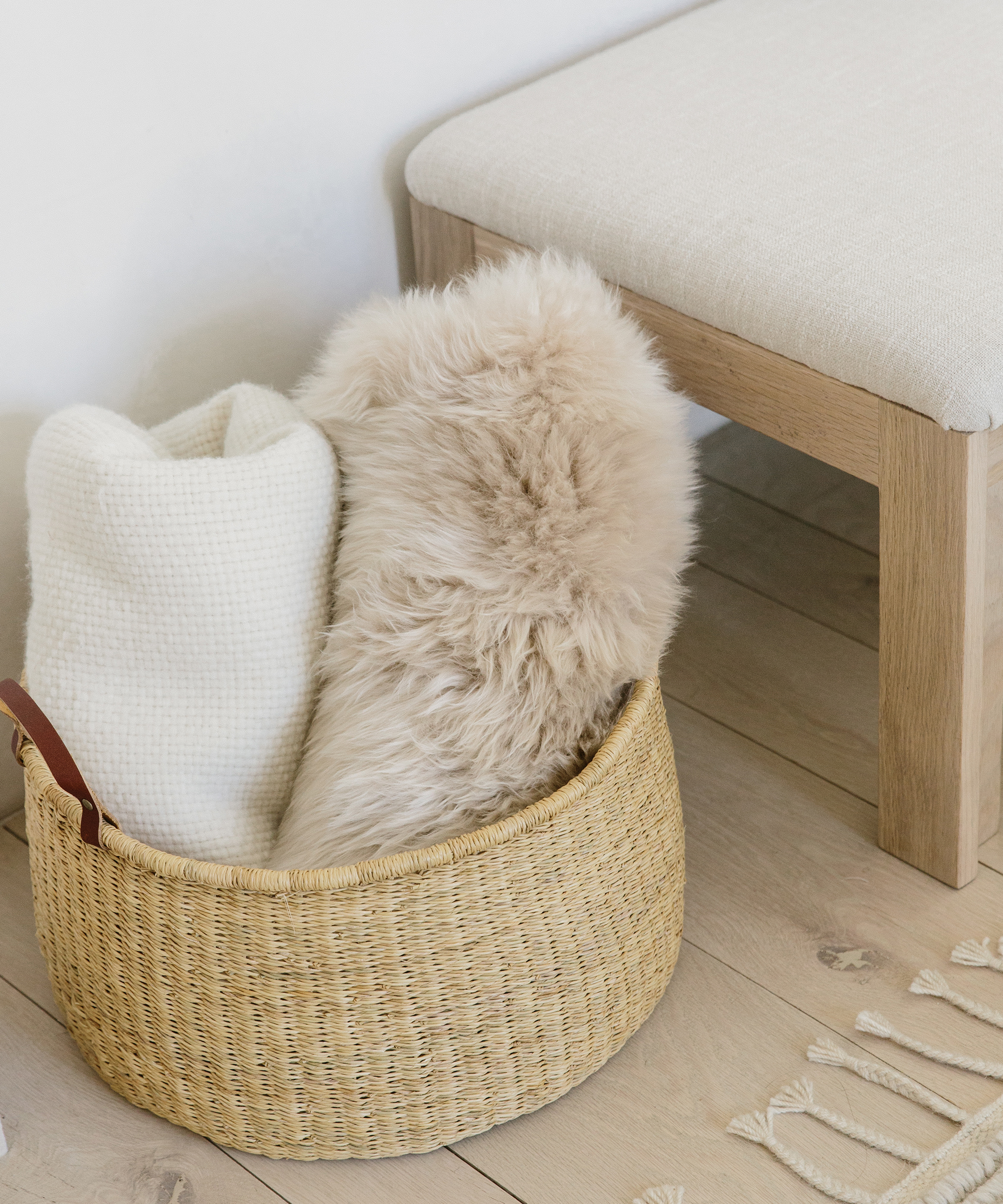 Jenni Kayne nesting baskets on the floor with sheepskin and throws folded up inside.