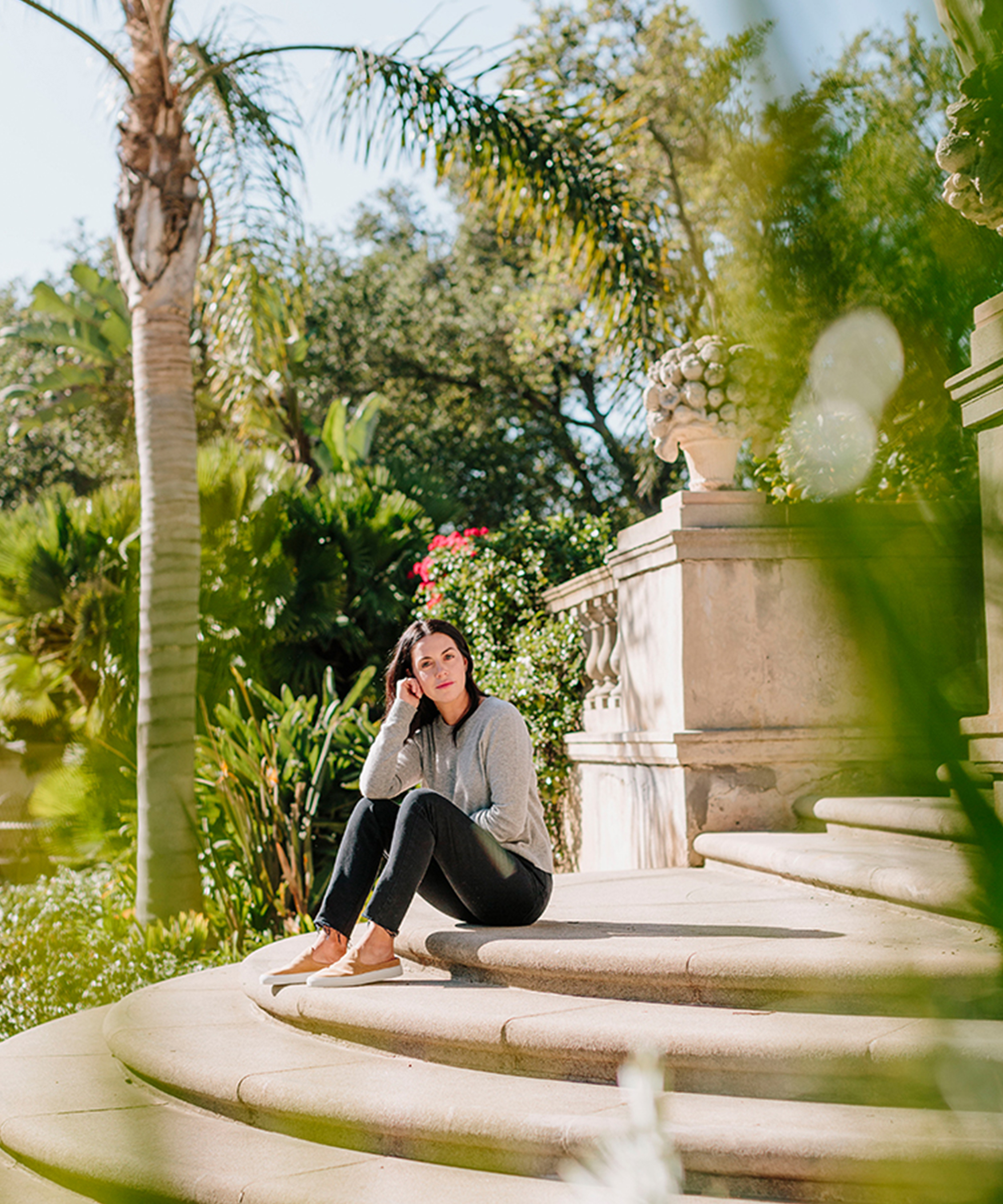 Brit Hines wearing jenni kayne everyday slim sweater and sneakers sitting on the steps outside of her montecito home.