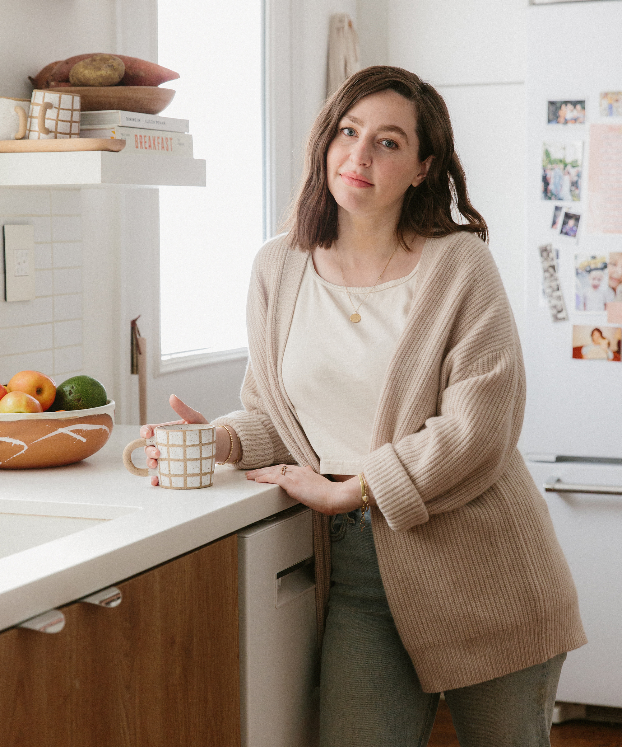 Molly Madfis of Almost Makes Perfect in her kitchen smiling with a jenni kayne cashmere cocoon sweater on.