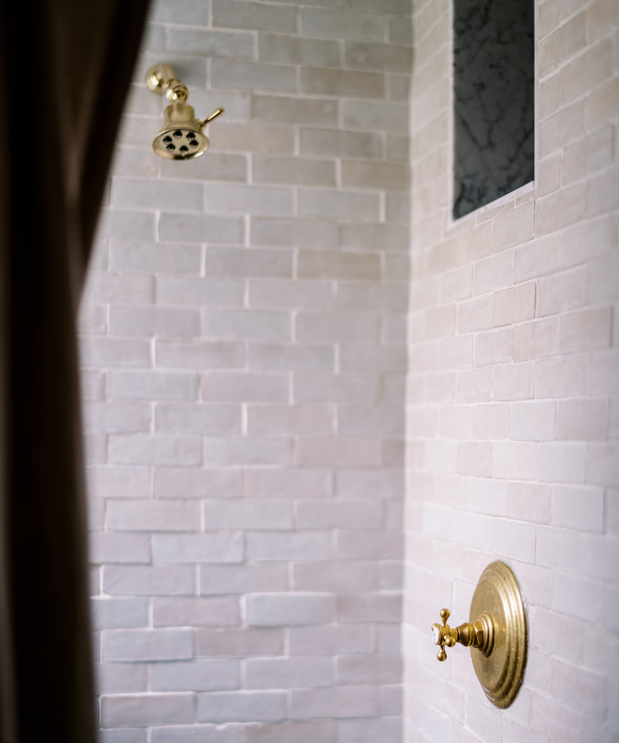 Kennesha Poe-Buycks of Restoration House's bathroom detail shot of textured tile and gold fixtures.