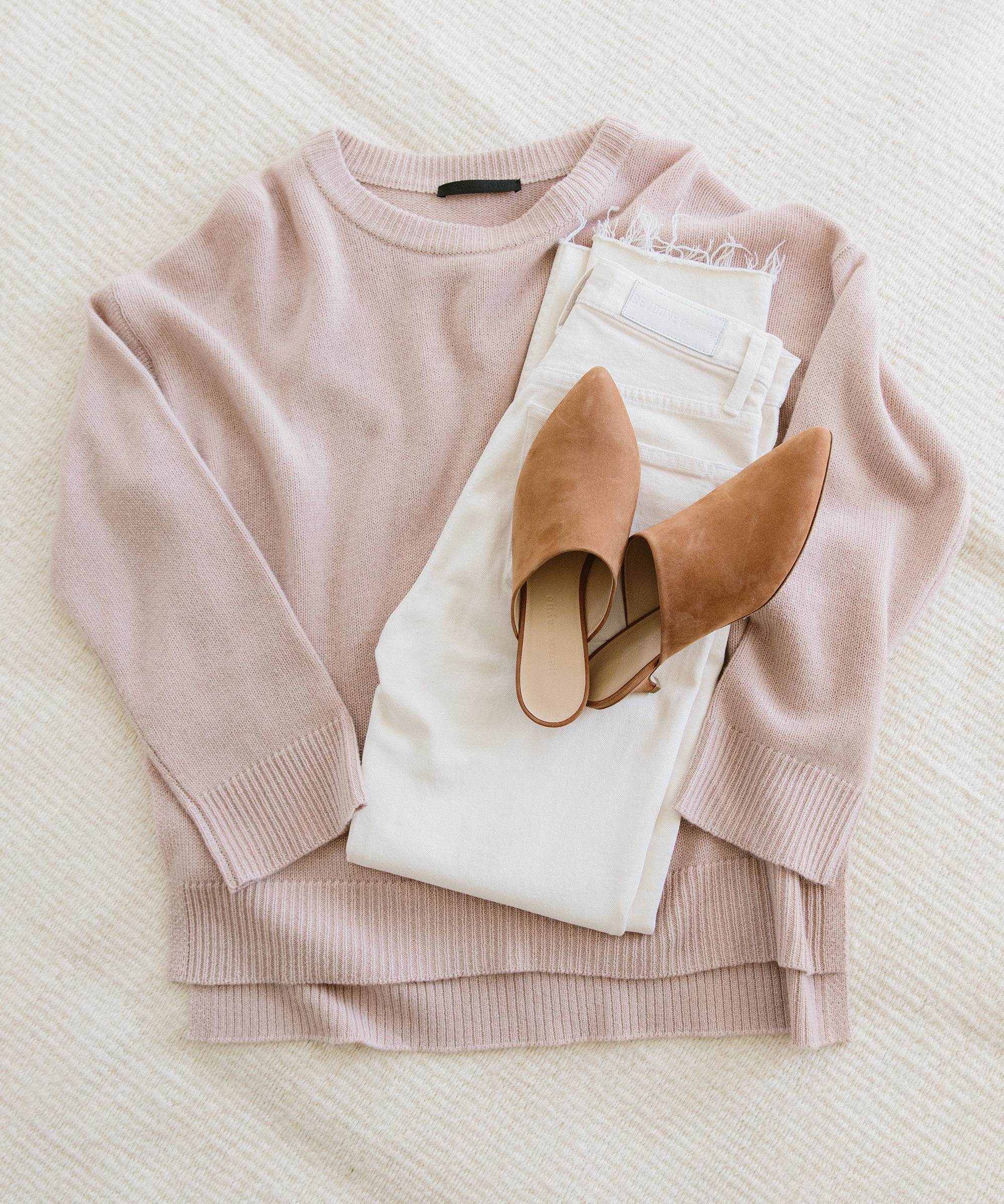 Jenni Kayne cashmere boyfriend sweater in blush with white jeans and oiled leather kitten heel mules on top.