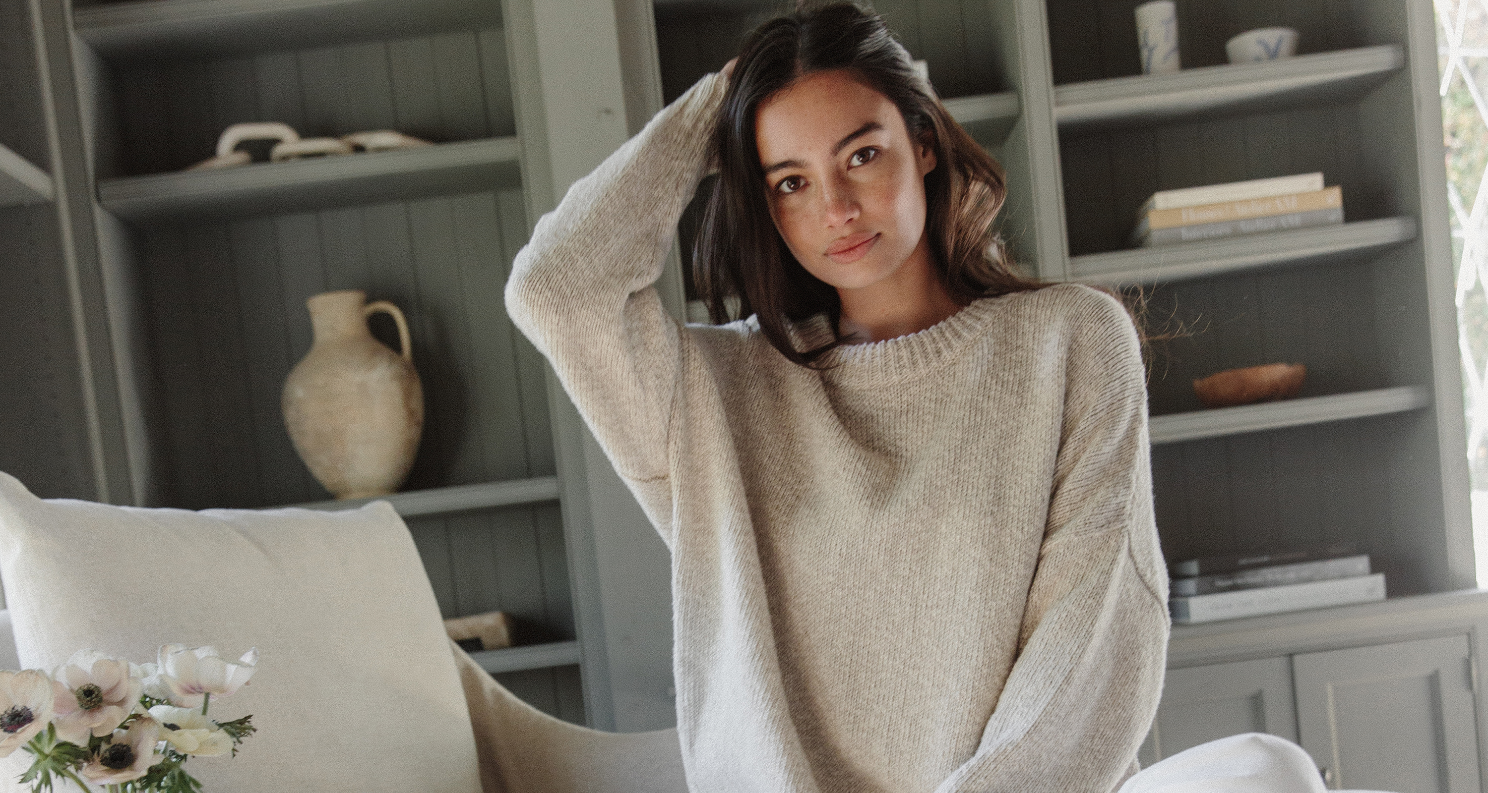 Jenni Kayne model wearing the cruise crewneck sweater with white jeans and sandals.