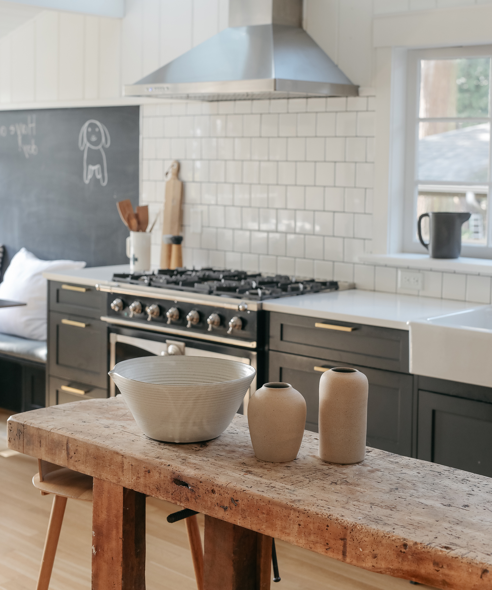 Sophie Burke's kitchen with a wooden table, black tabletops, and tiled walls.