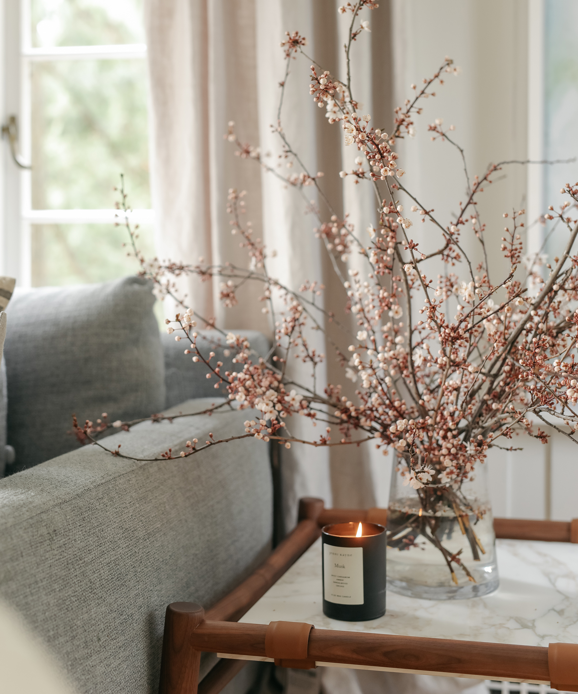 Close up shot of an arrangement on a table with a jenni kayne candle burning at sophie burke's home.