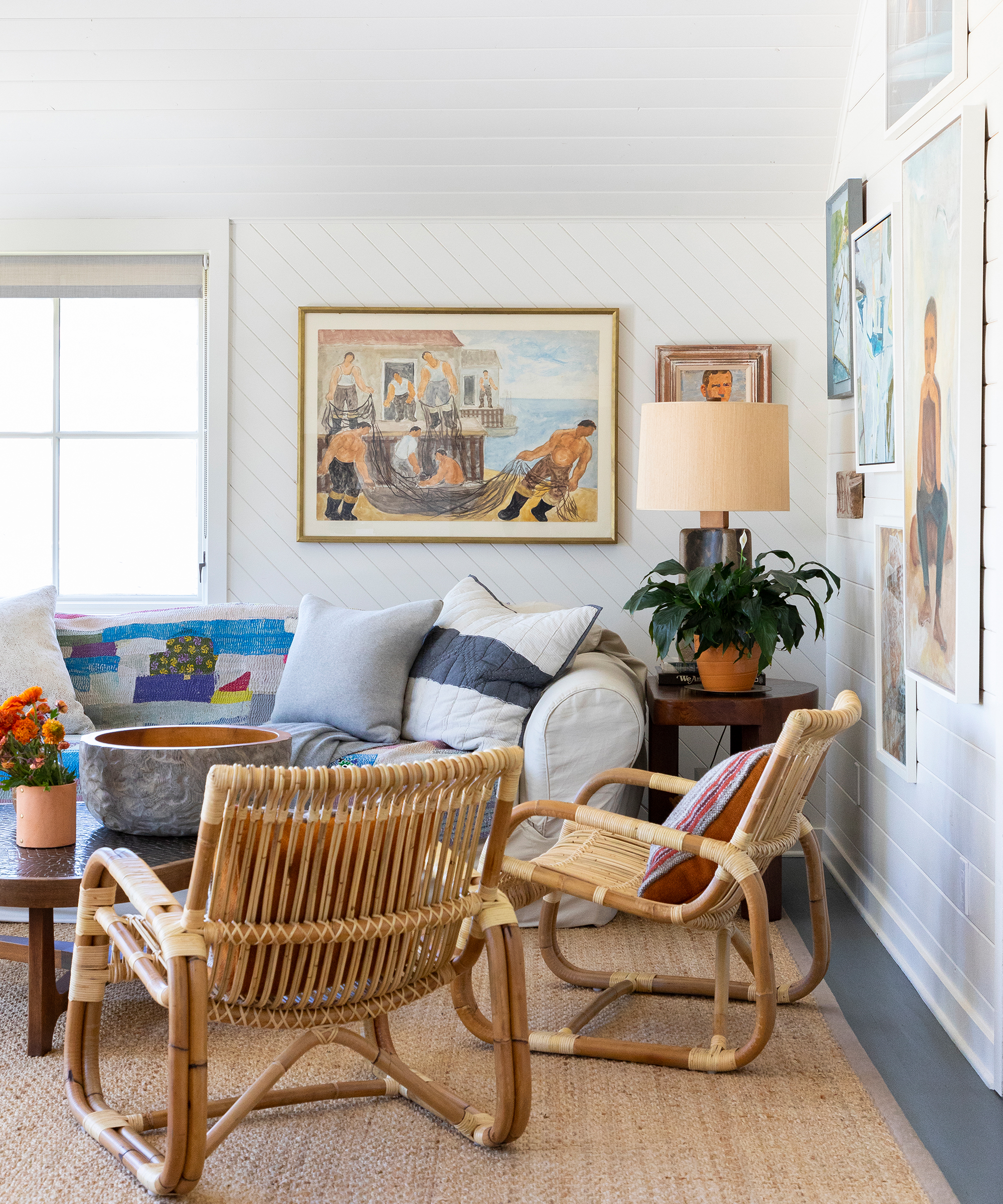 Tim Pfeiffer's living room with whicker chairs, a sofa in the background, and pictures on the walls.