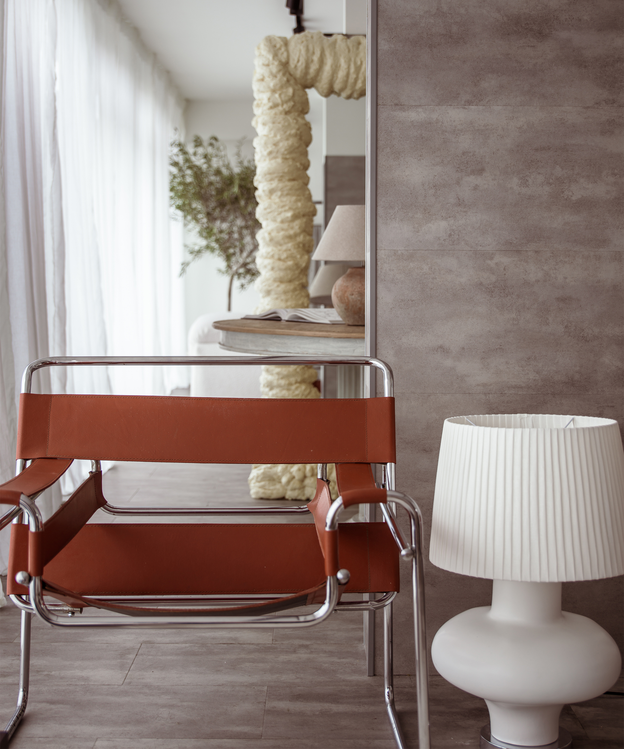 Shot of Abisola Omole's London N1 Studio with a leather chair and white lamp on the floor next to it.