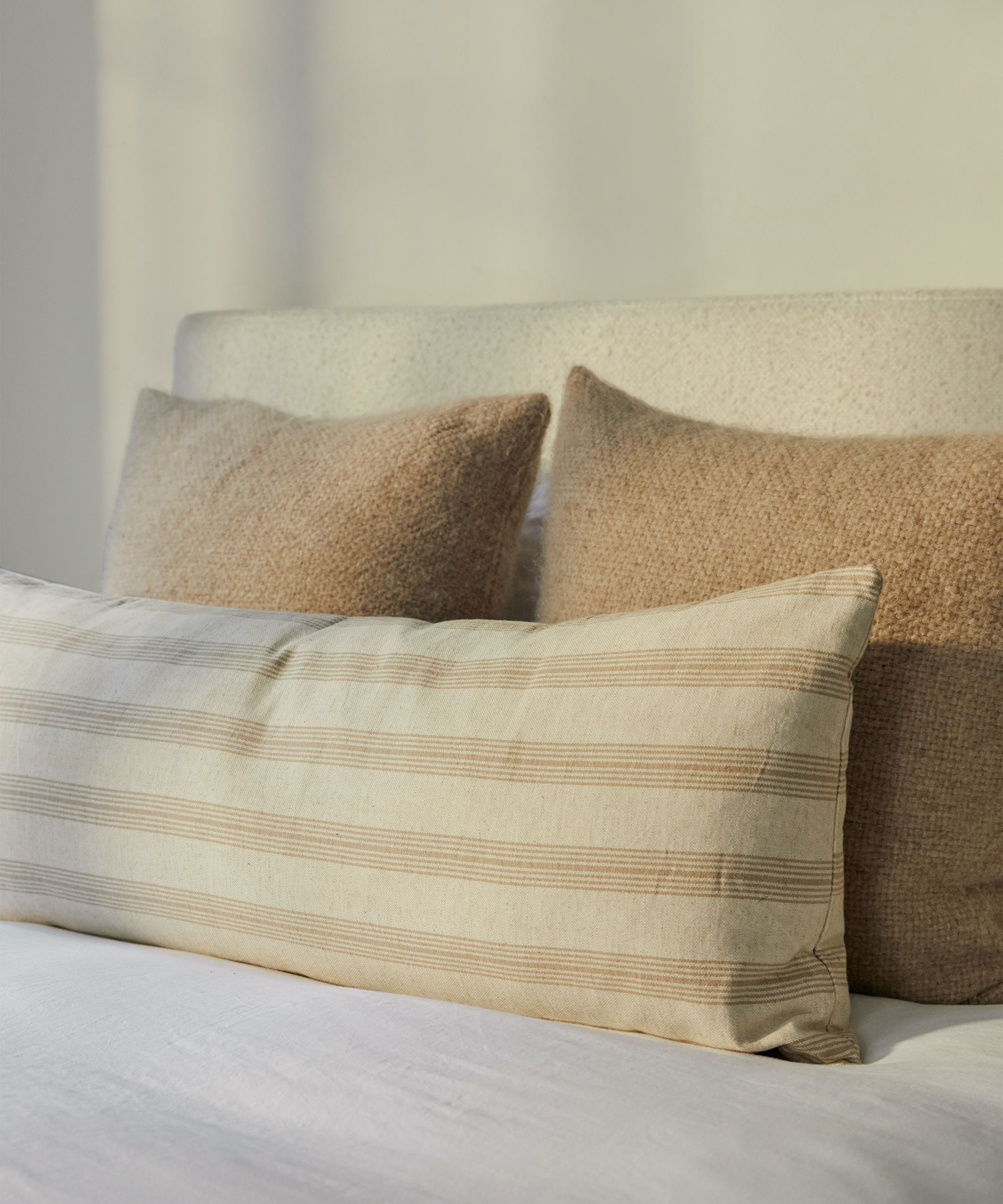 Close up of jenni kayne pacific bed with an assortment of pillows on top.