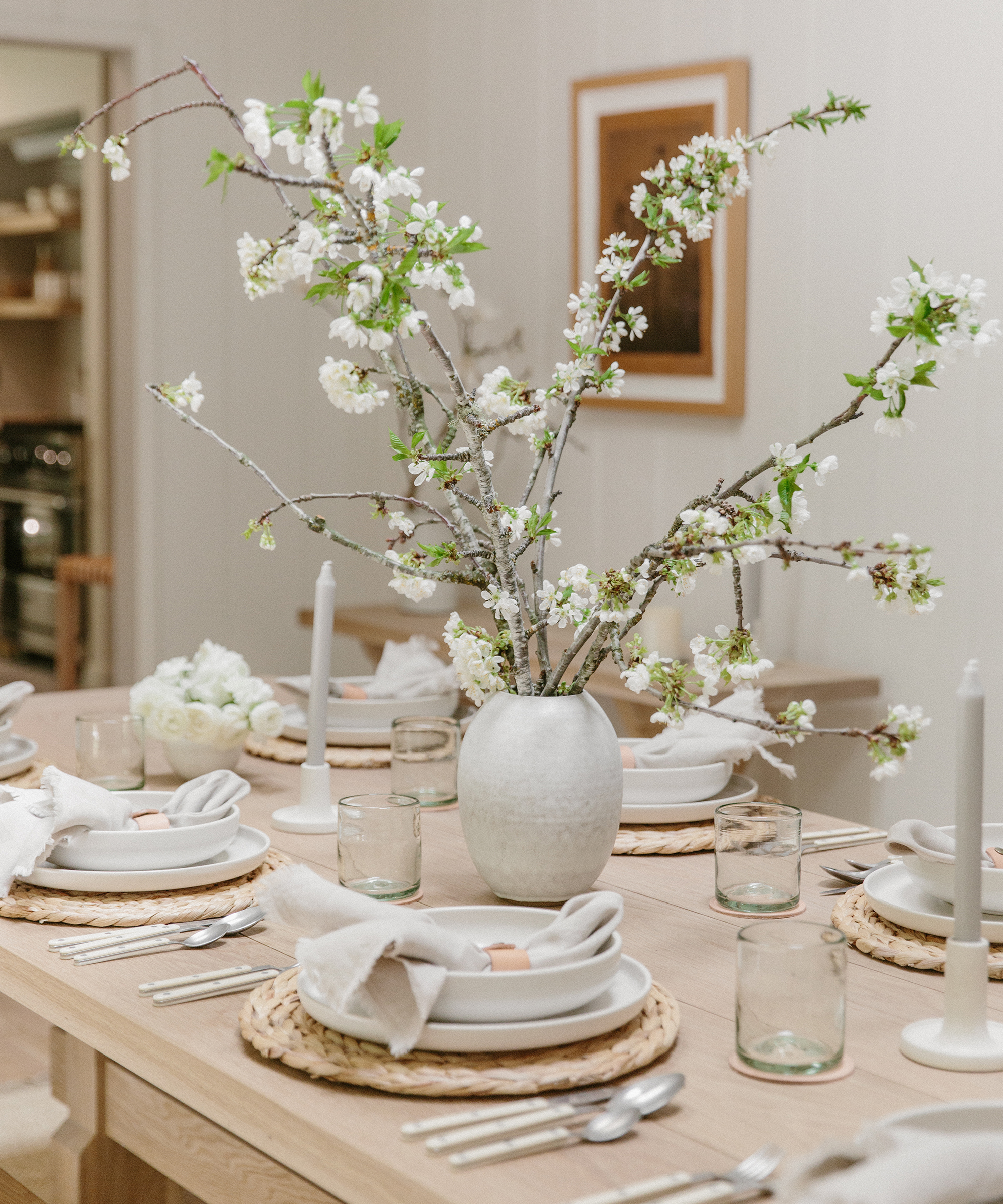 Julia Hunter's dining room with jenni kayne oak dining table and oak benches with white walls, farmhouse rug, and sierra dinnerware on top.
