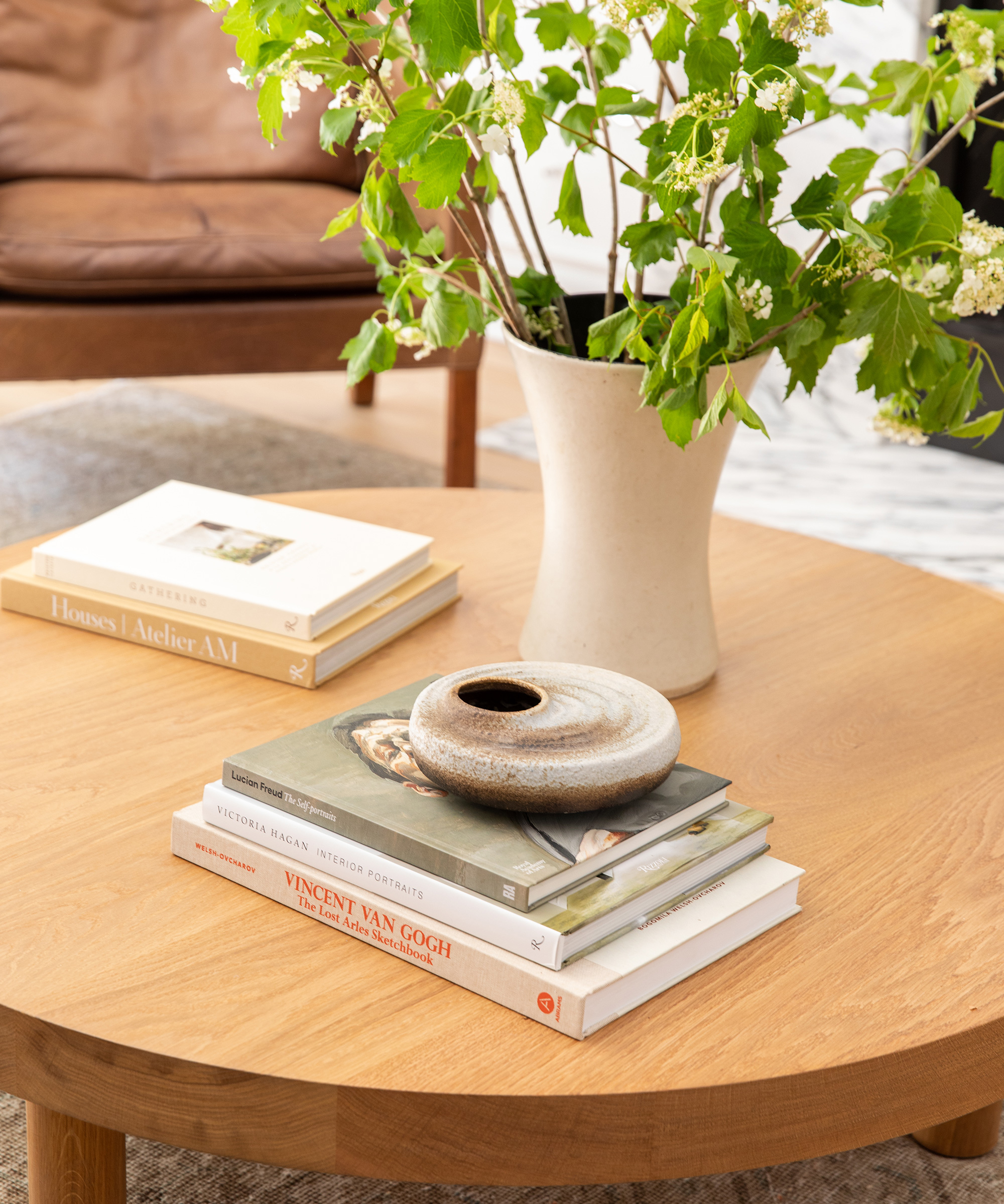 Close up shot of Emily Schuman's living room coffee table with greenery and books.
