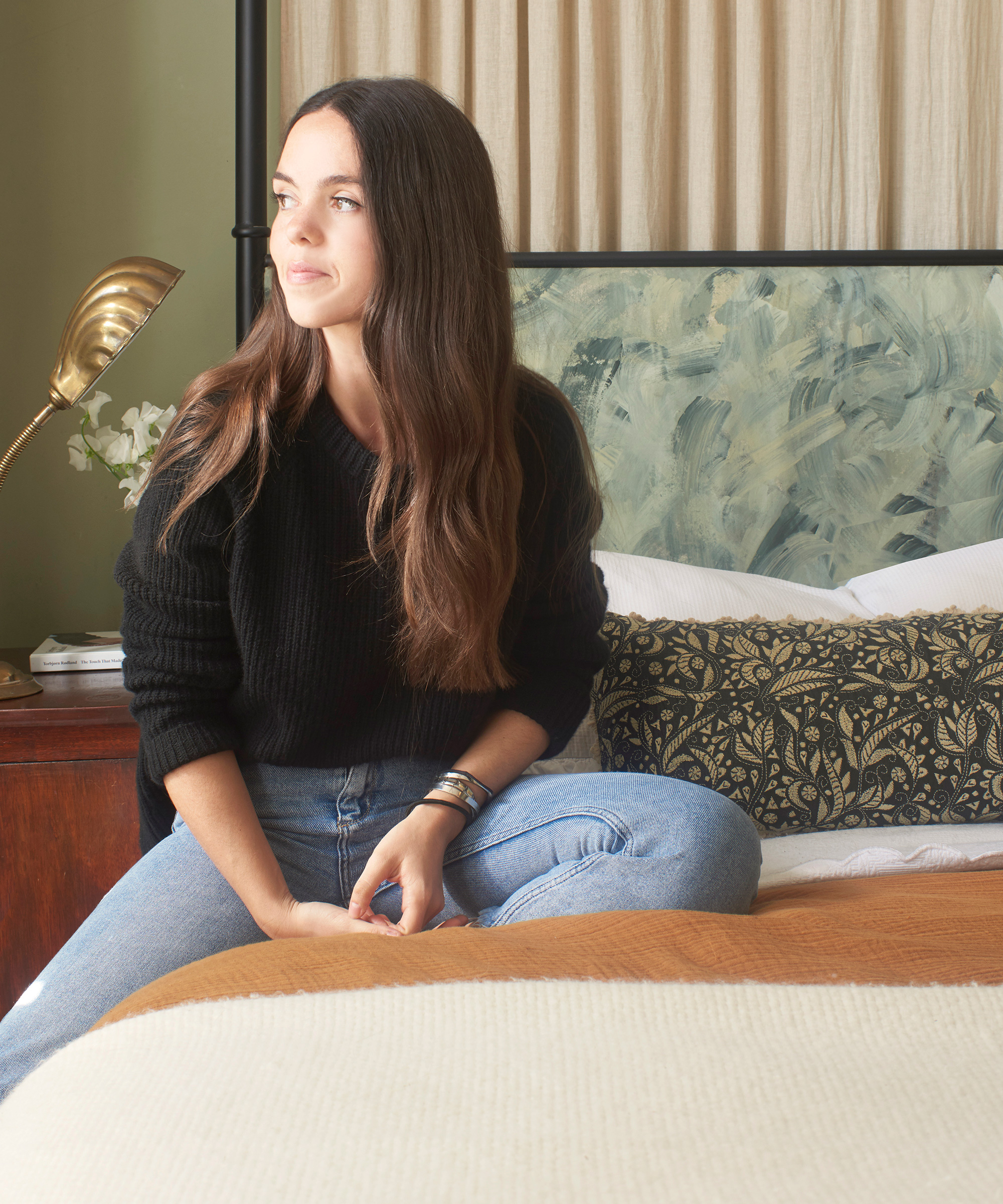 Sacal Studio sister sitting on the bed.