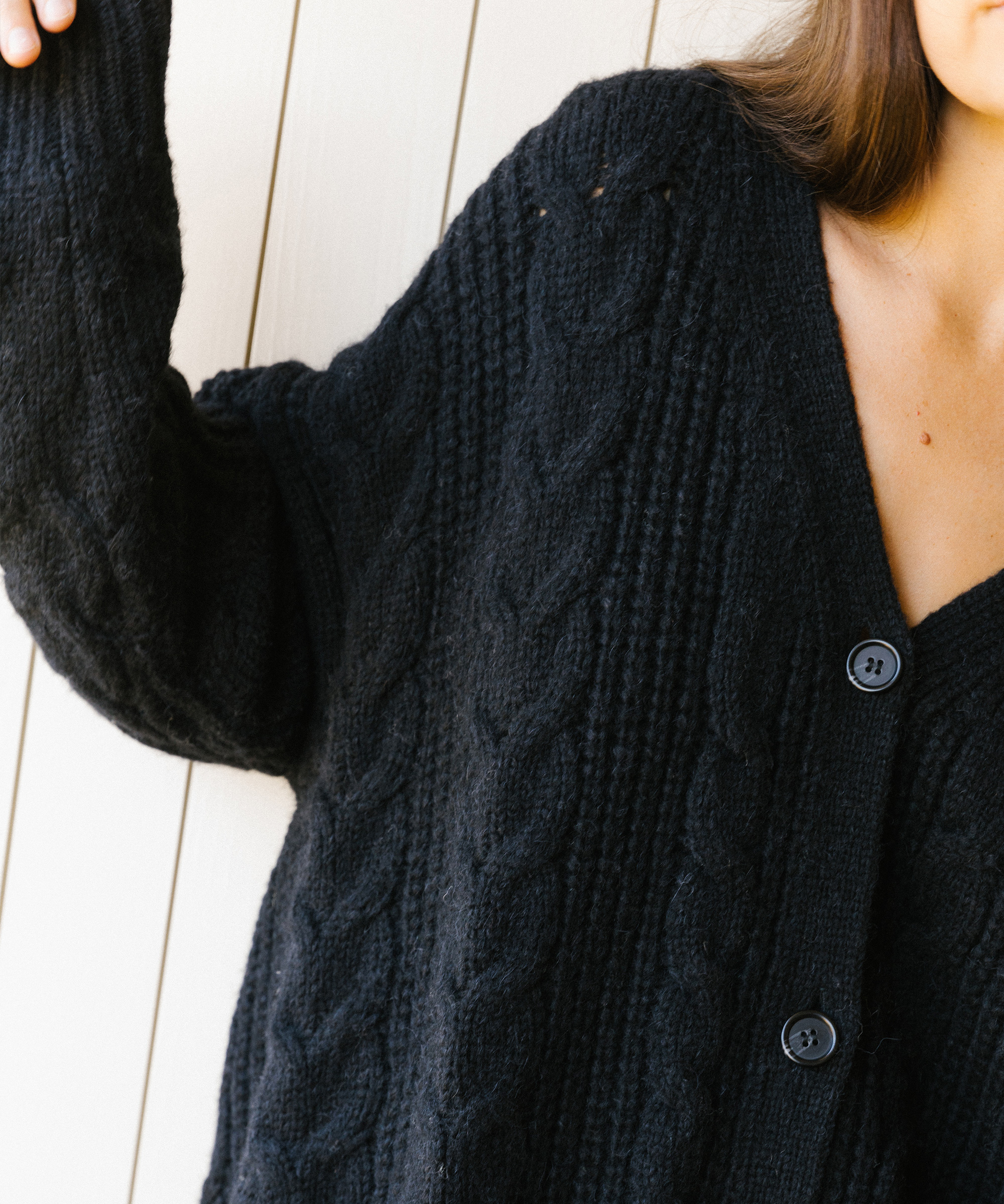 model wearing jenni kayne cable cocoon cardigan in black.