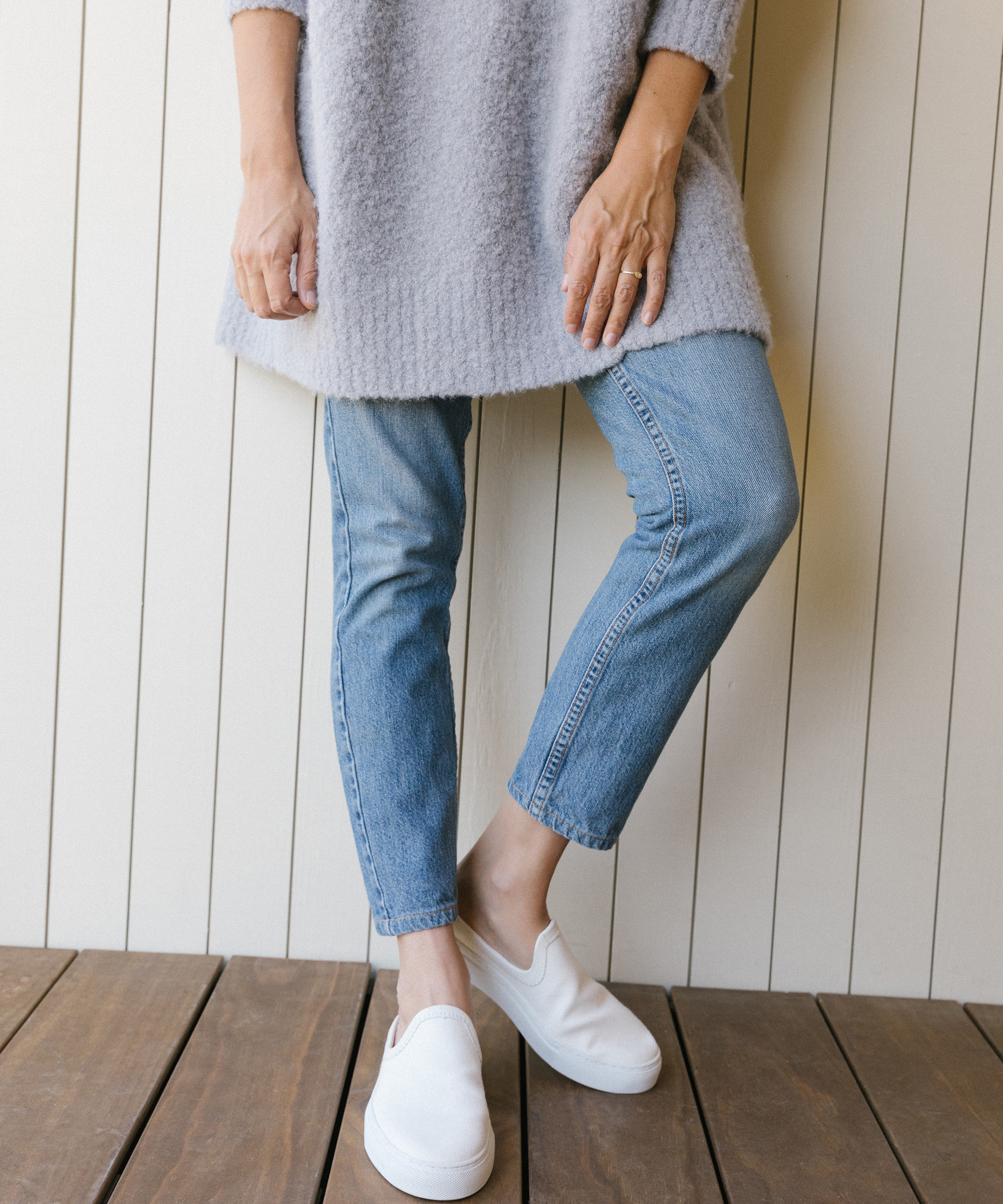 model wearing boucle cocoon crewneck in frost with jeans and canvas slide on sneakers.