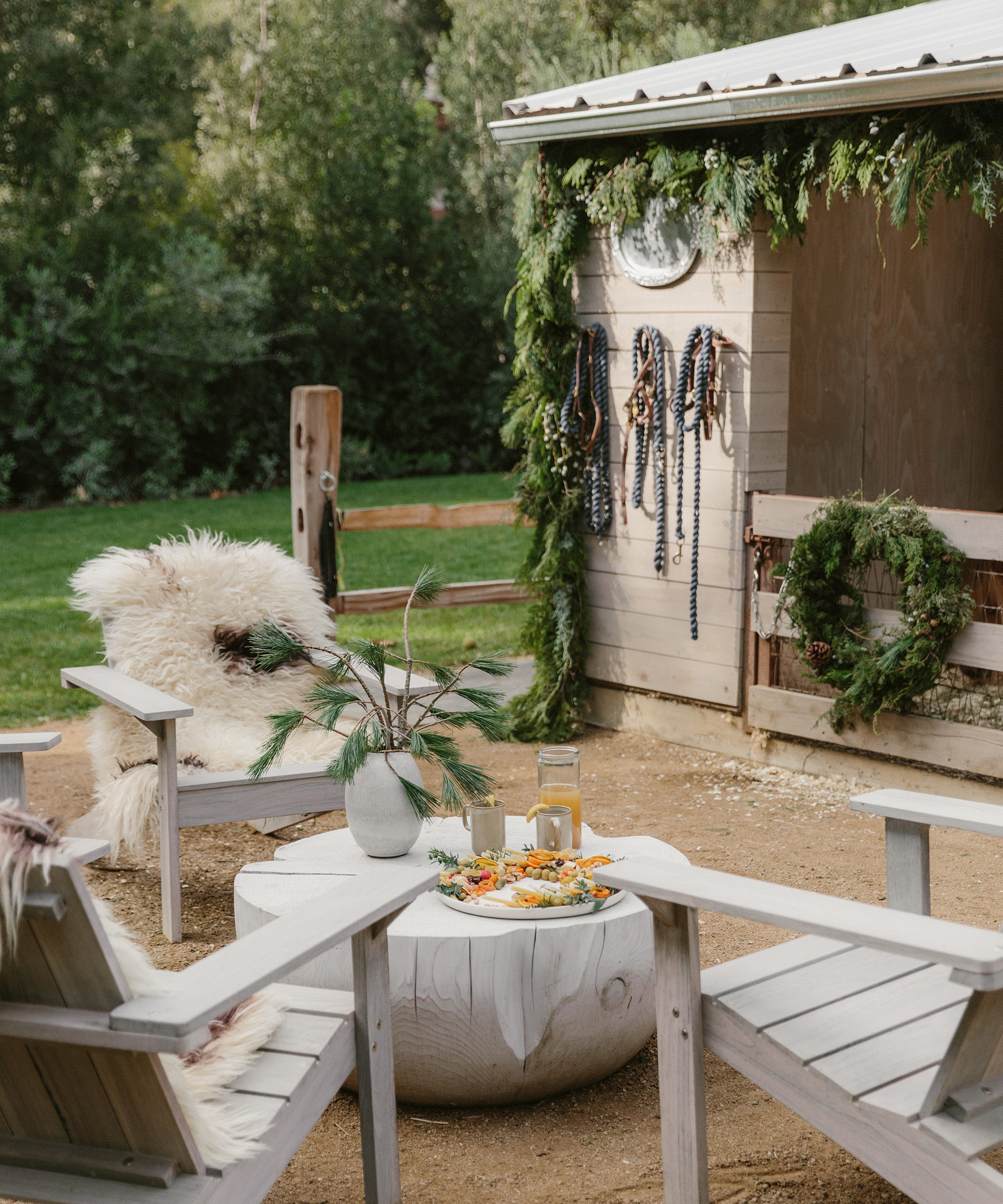table and chairs outdoors with sheepskin on top of it and seasonal appetizers