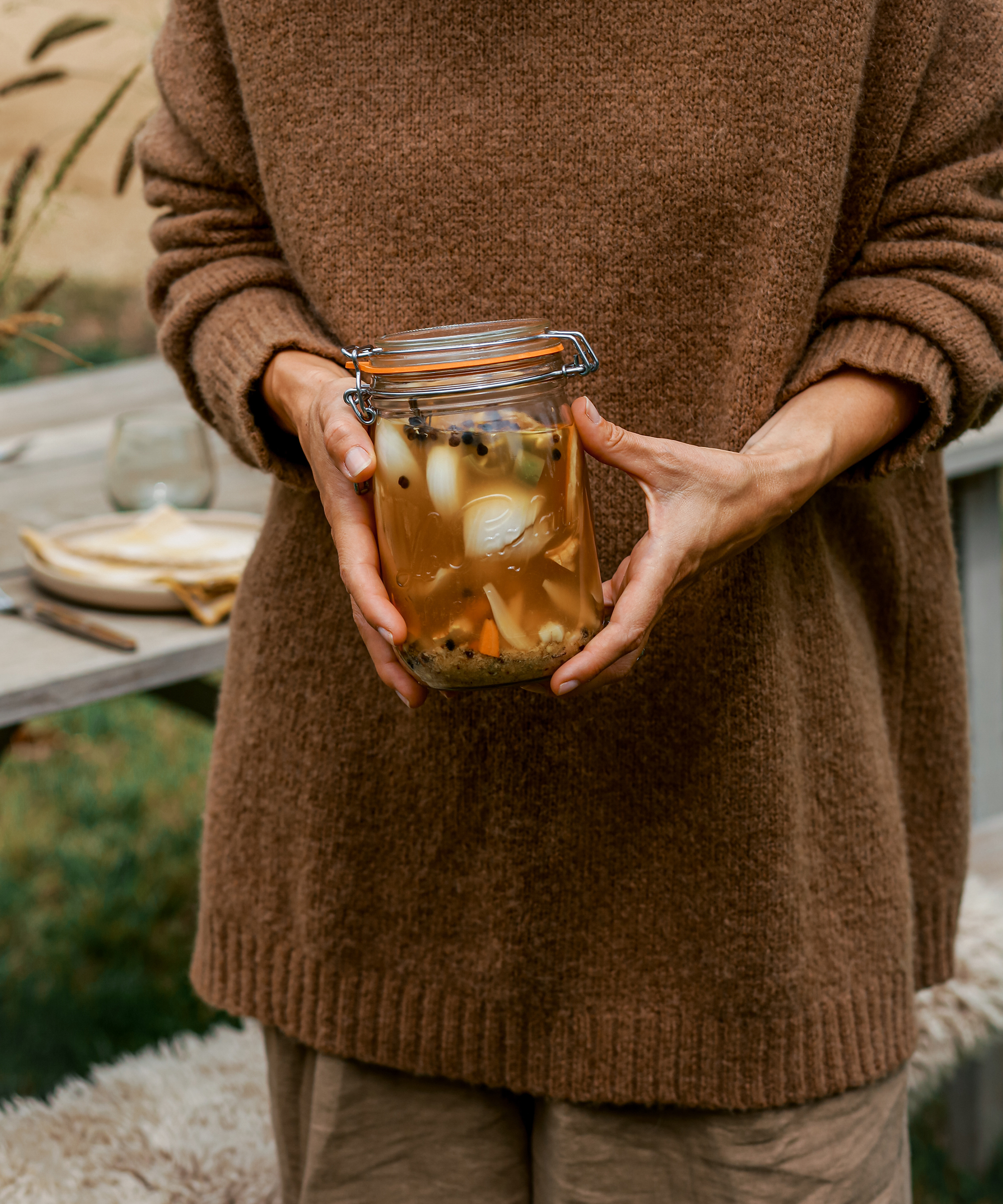 image of jenni holding a jar of fire cider