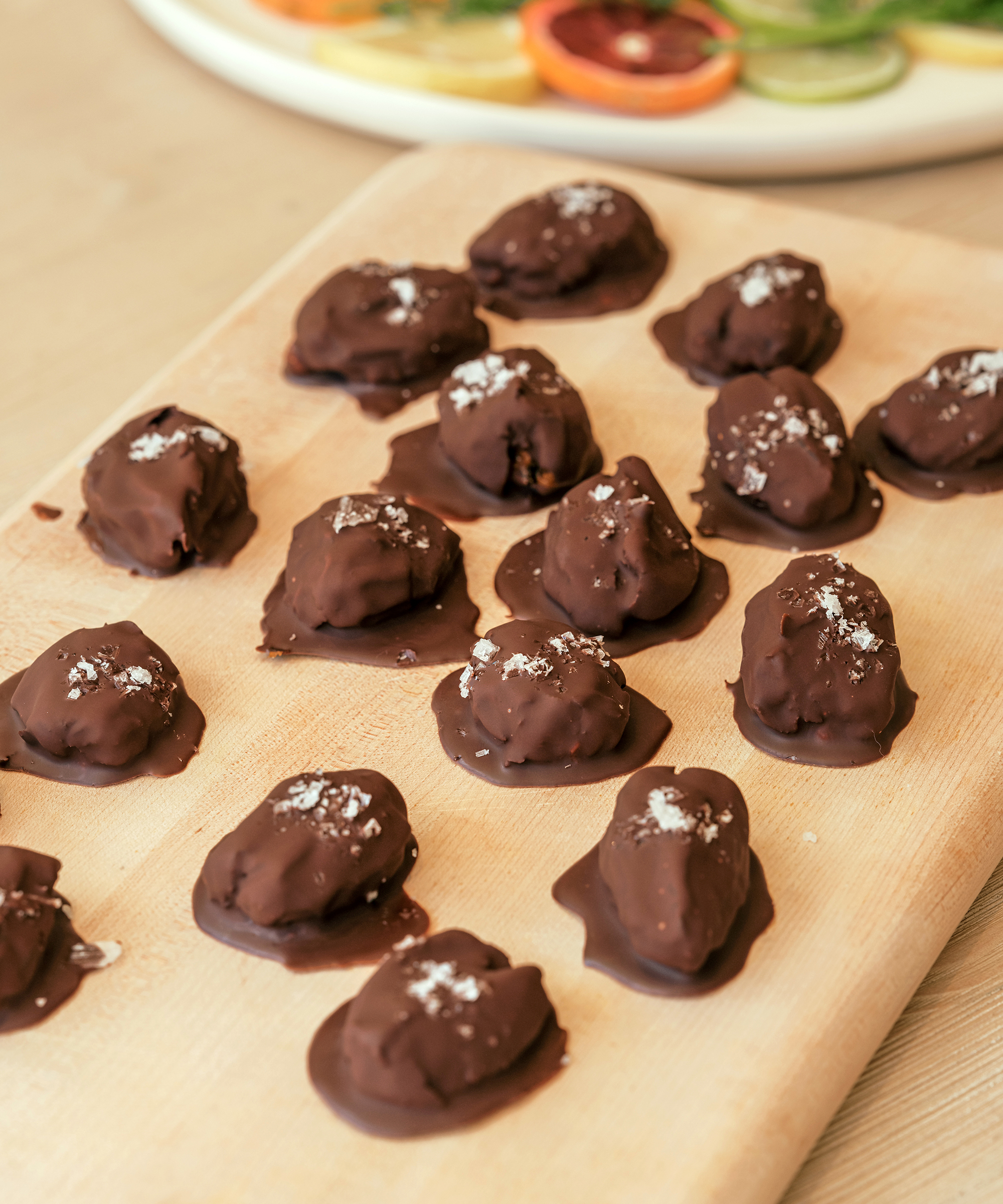 chocolate covered dates with salt on wooden serving board