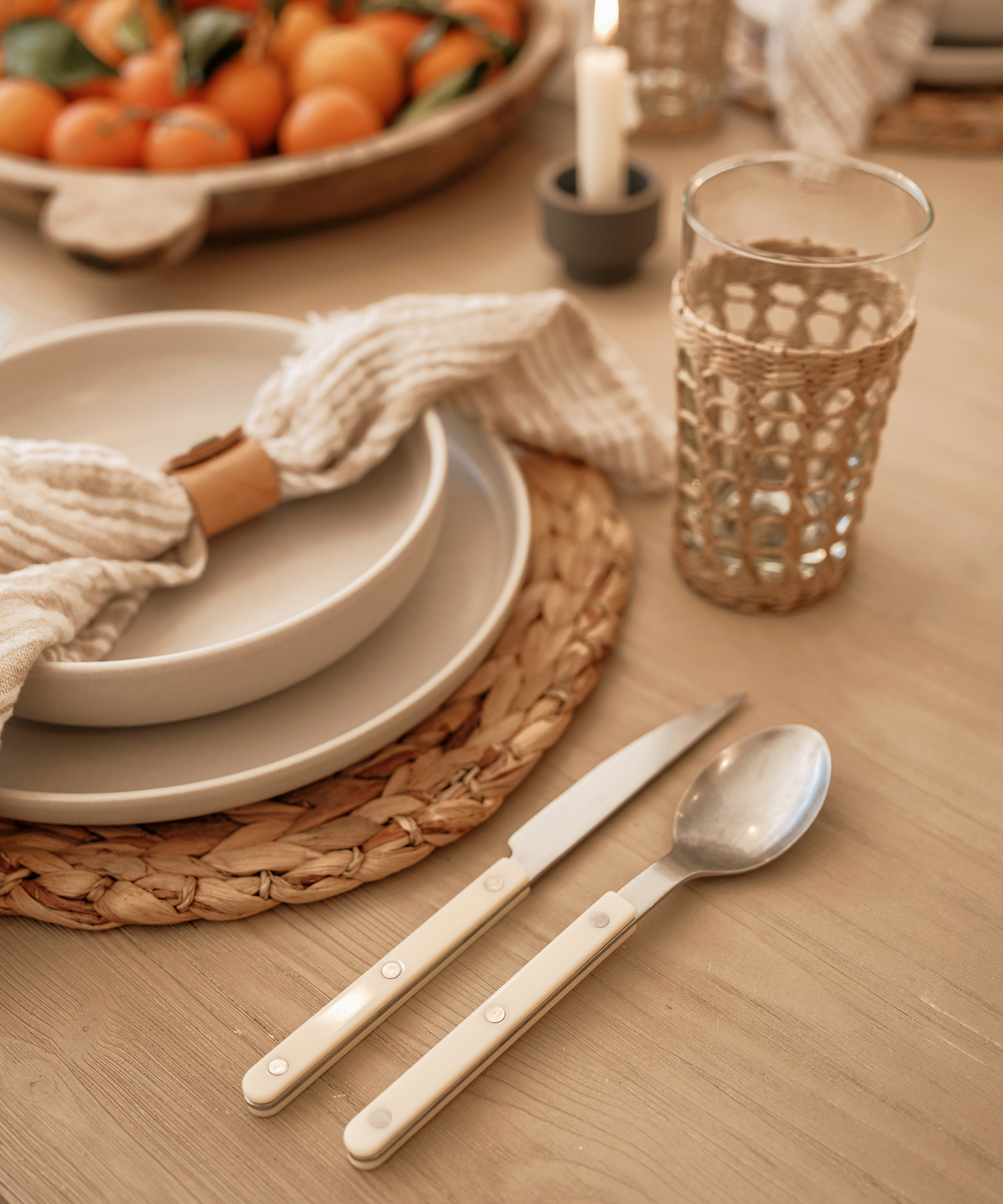 woven charger with an ivory plate and soup bowl and white acrylic silverware