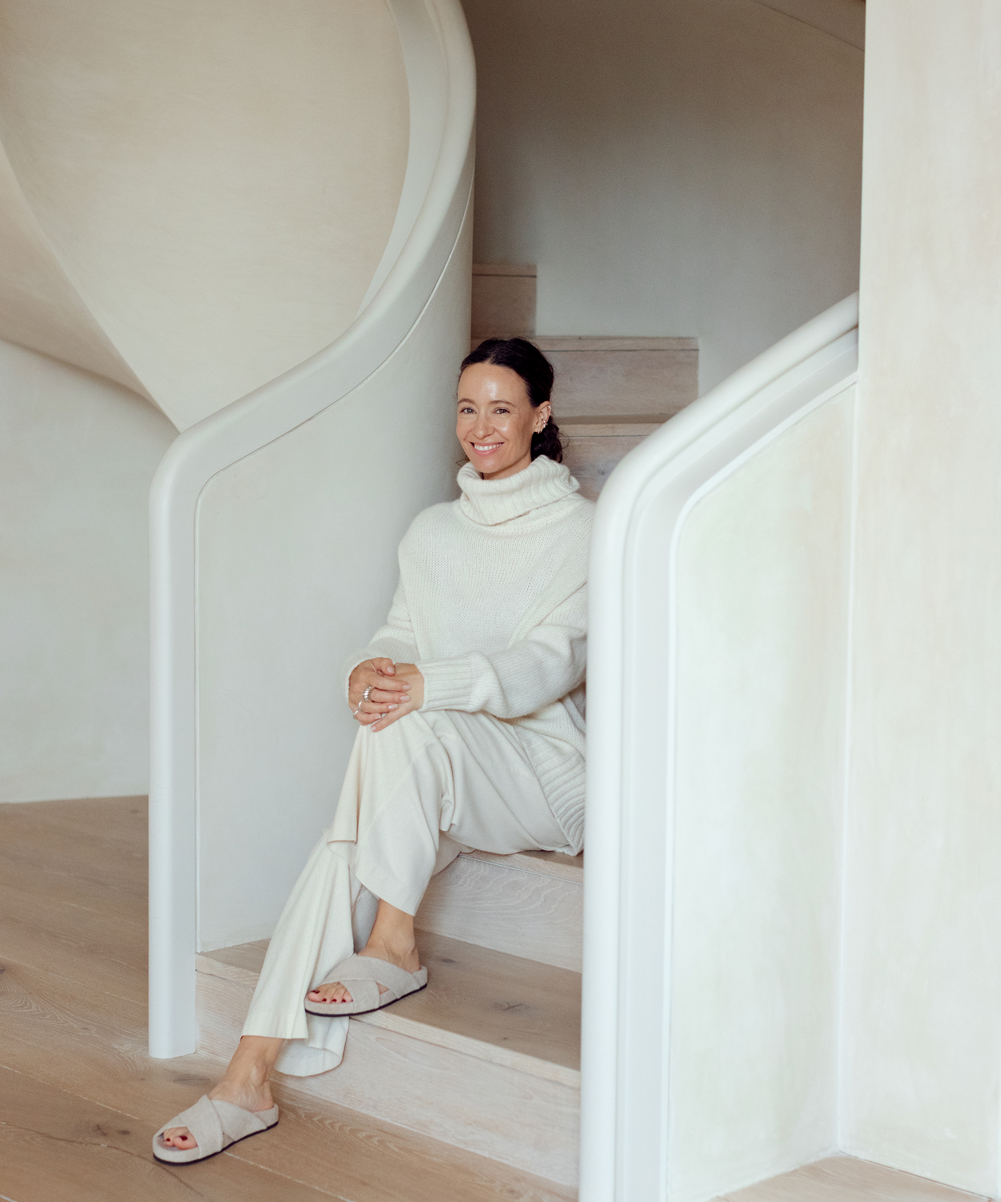 photo of jenni kayne sitting in stairwell in all white outfit