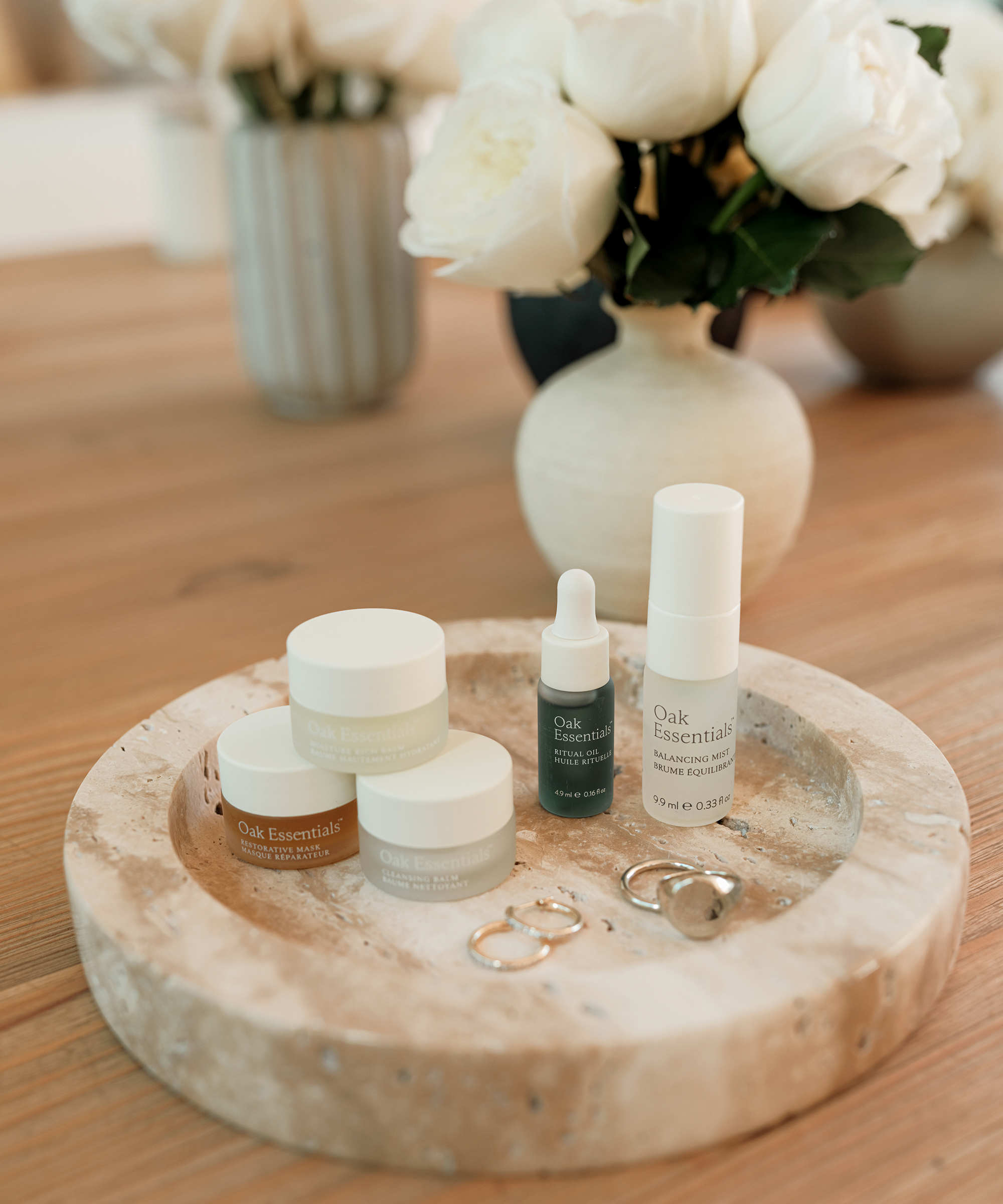 marble tray on a table with gold rings and earrings and a mini beauty set from oak essentials