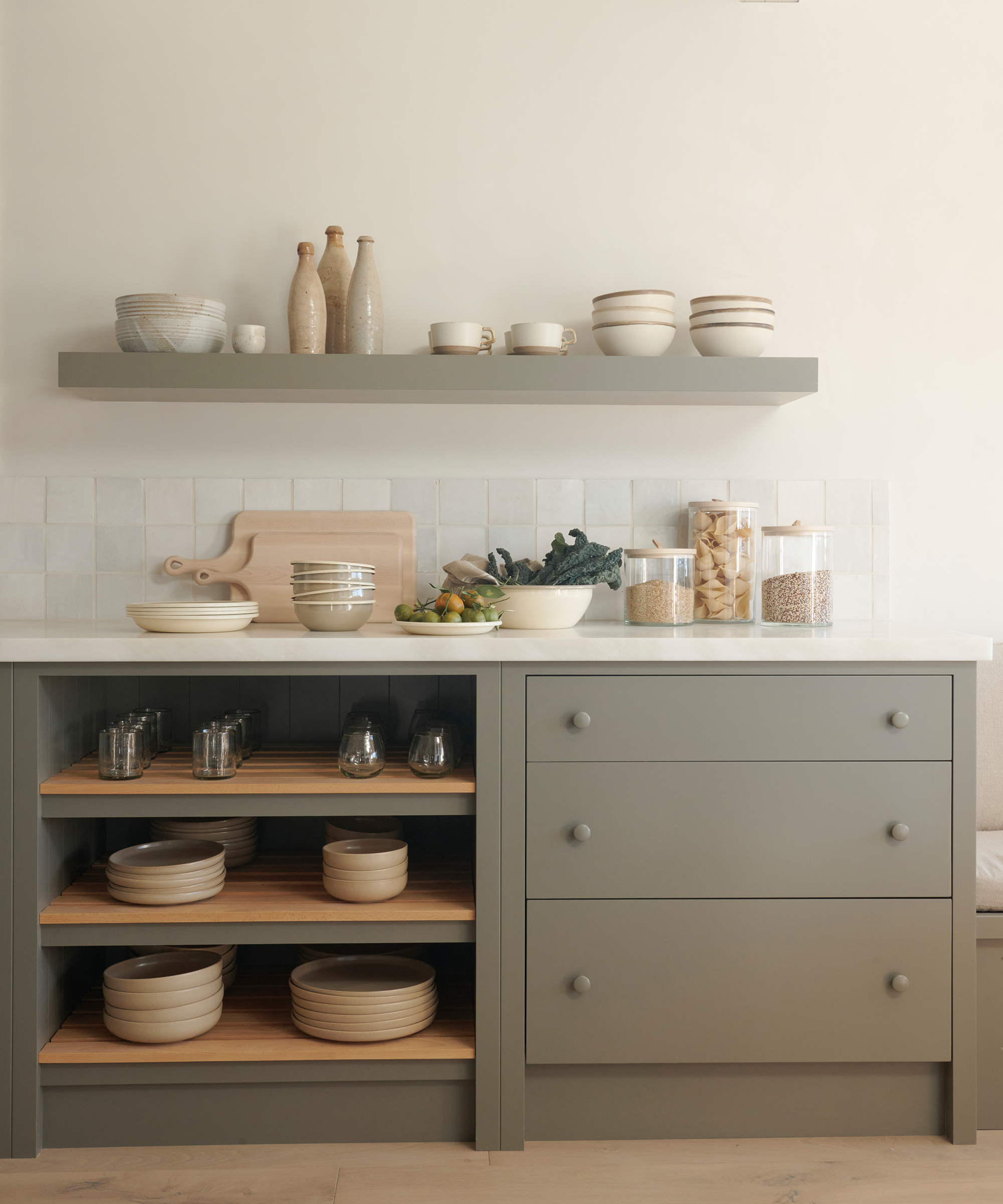 light green grey kitchen cabinets with built in shelving and and open shelving above the white counters