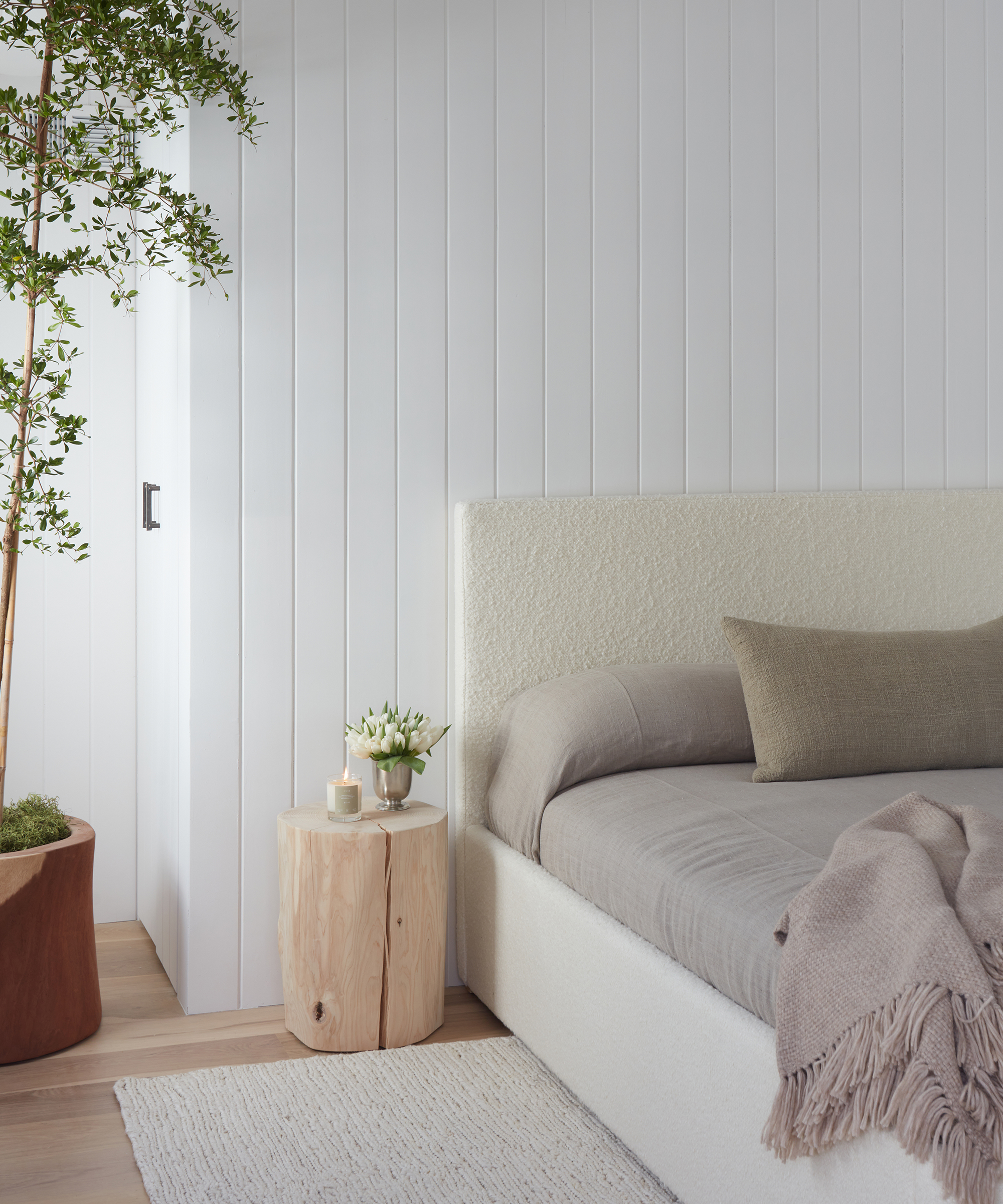 bedroom with the pacific bed and grey bedding next to a cedar stump side table