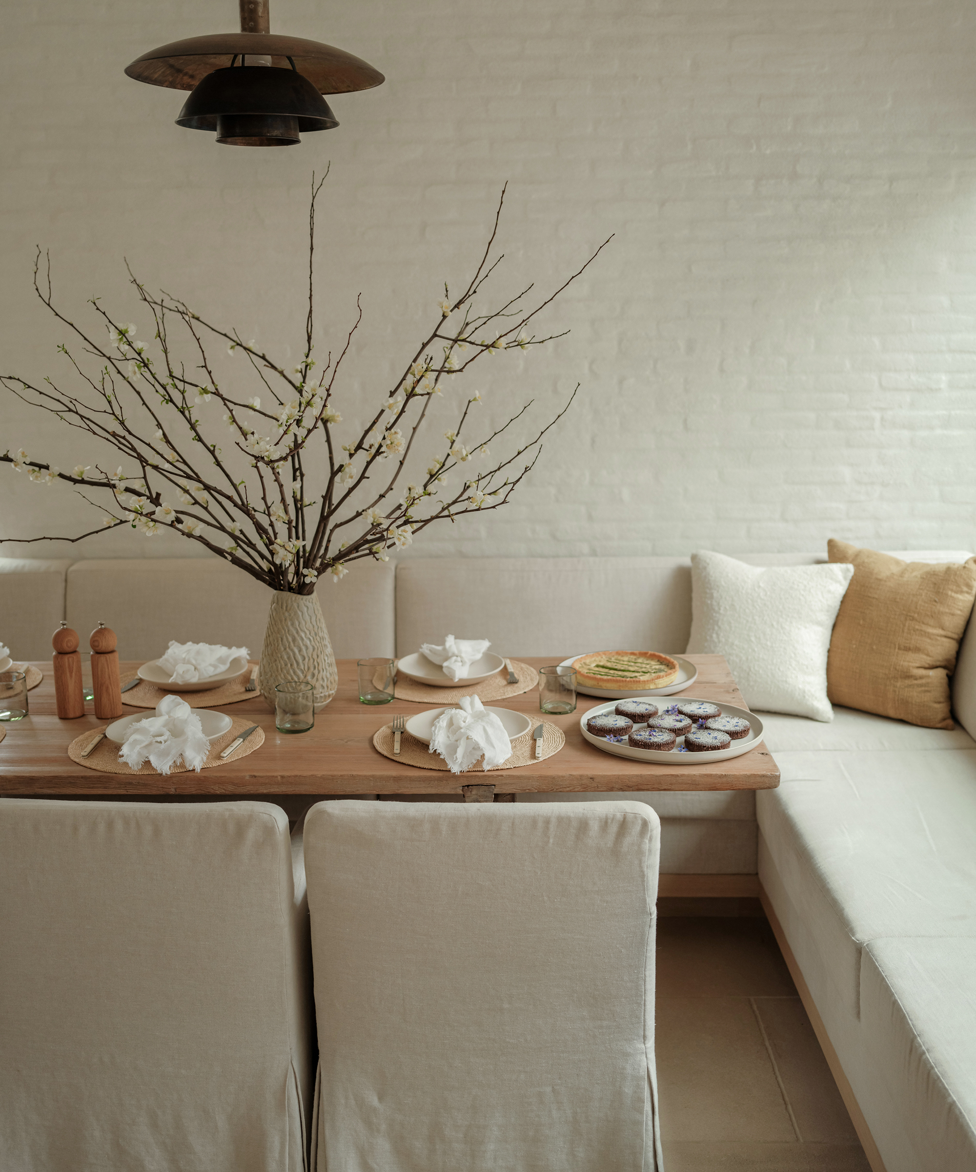 kitchen nook with a set table and food on platters in a neutral palatte