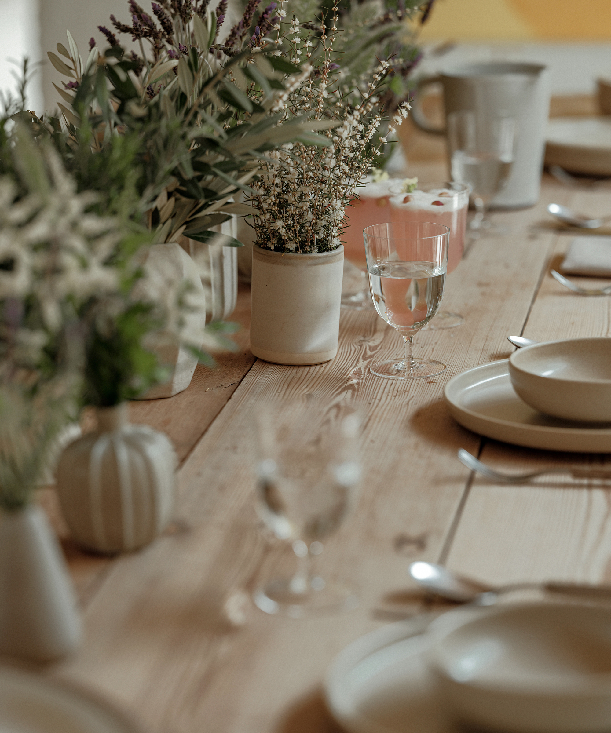 oak dining table with green florals and taupe dinnerware and clear water glasses