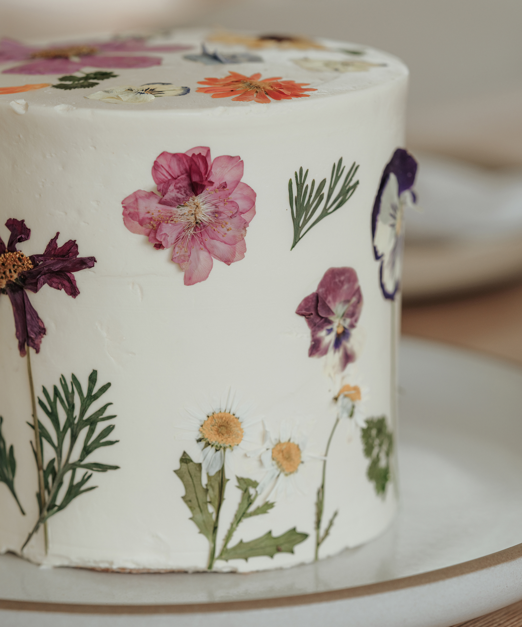 close up photo of a floral cake on an ivory sierra platter