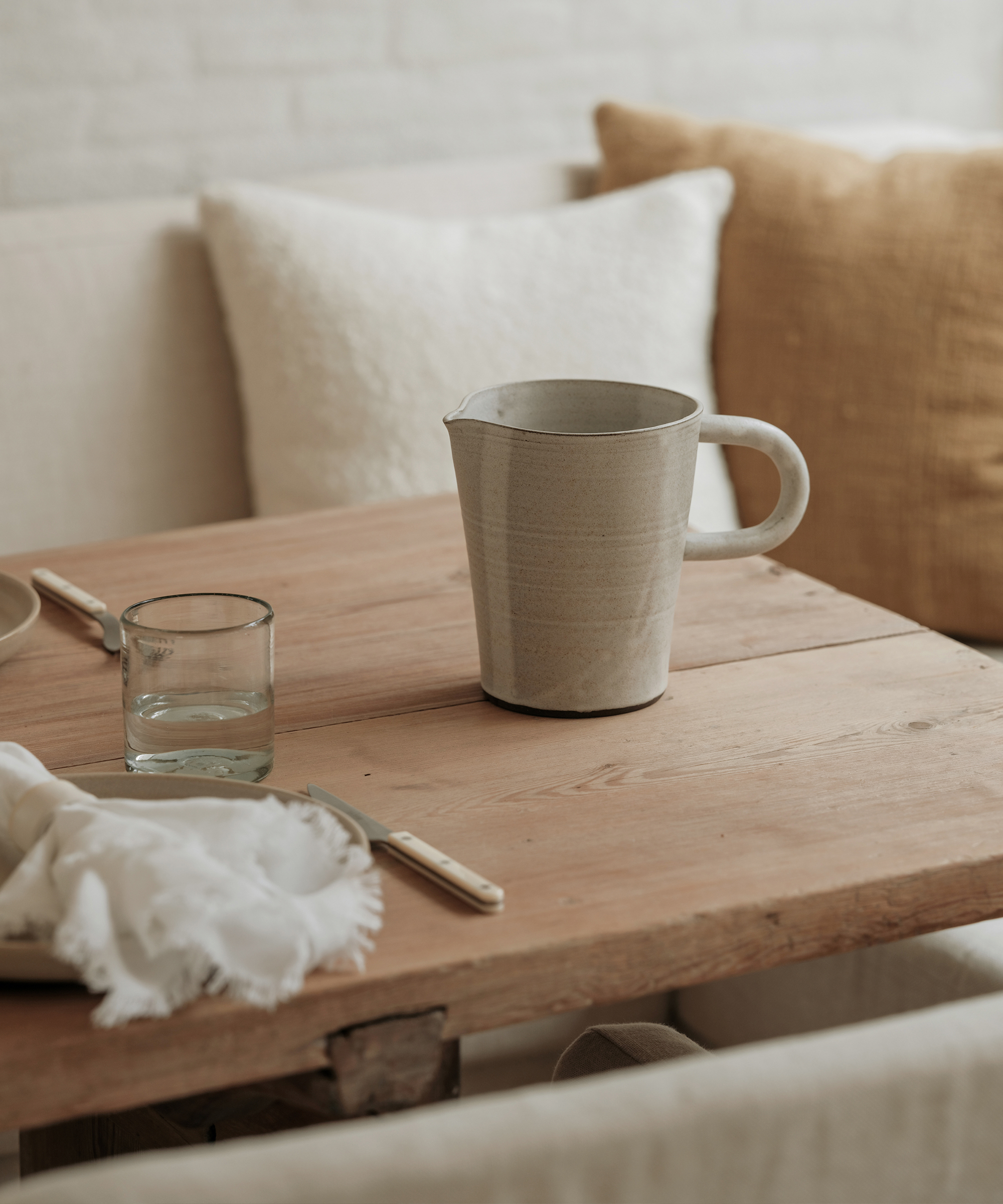 kitchen nook with an oak dining table and taupe drinking pitcher