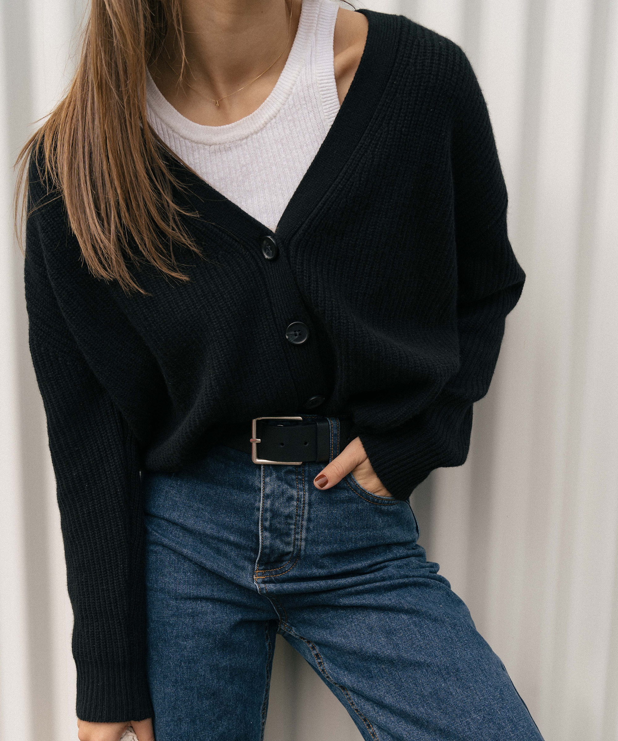 close up photo of a woman in a cropped cocoon cardigan and a white tank styled with blue jeans