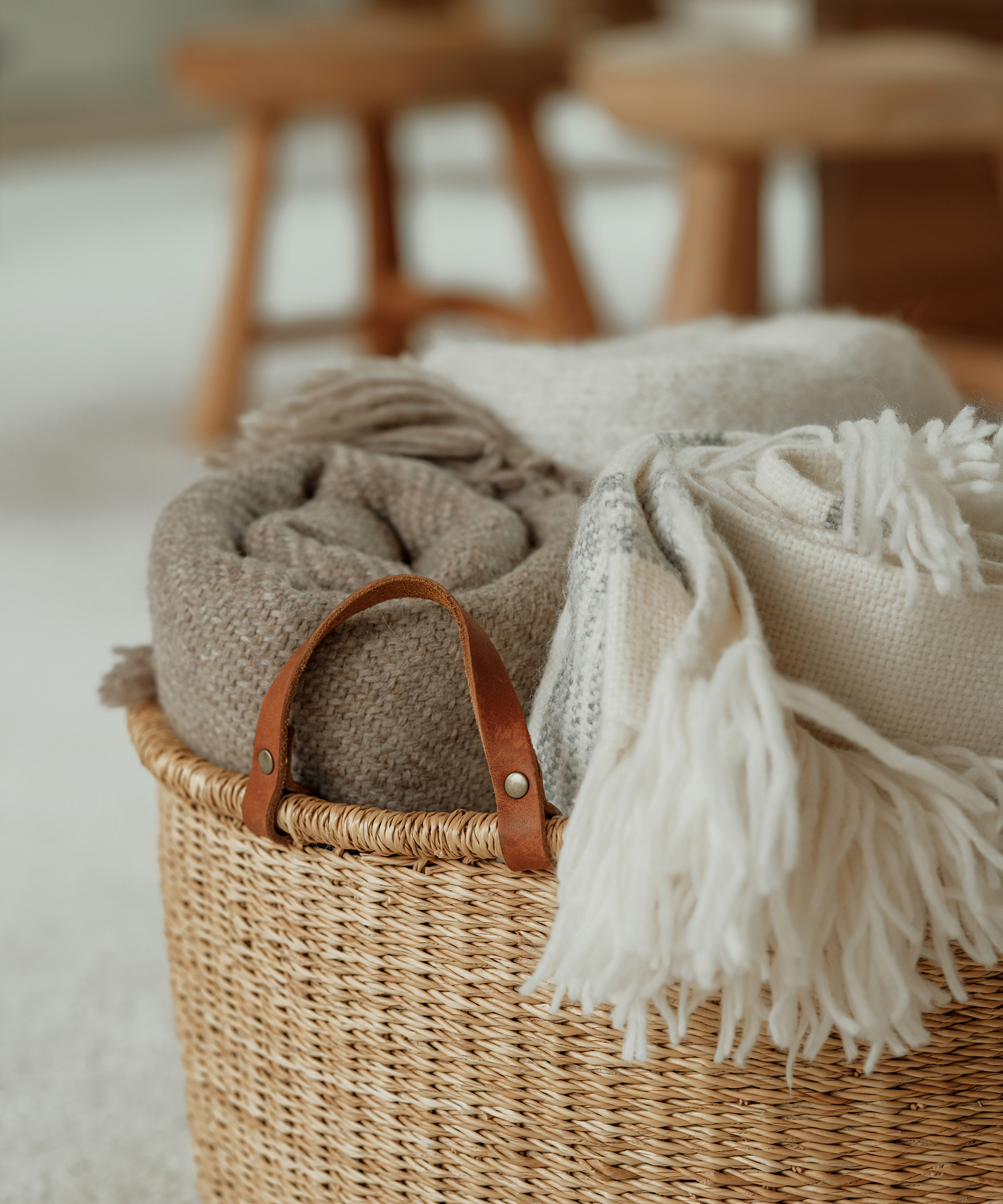 tan nesting basket with three throws including one oatmeal and an ivory throw