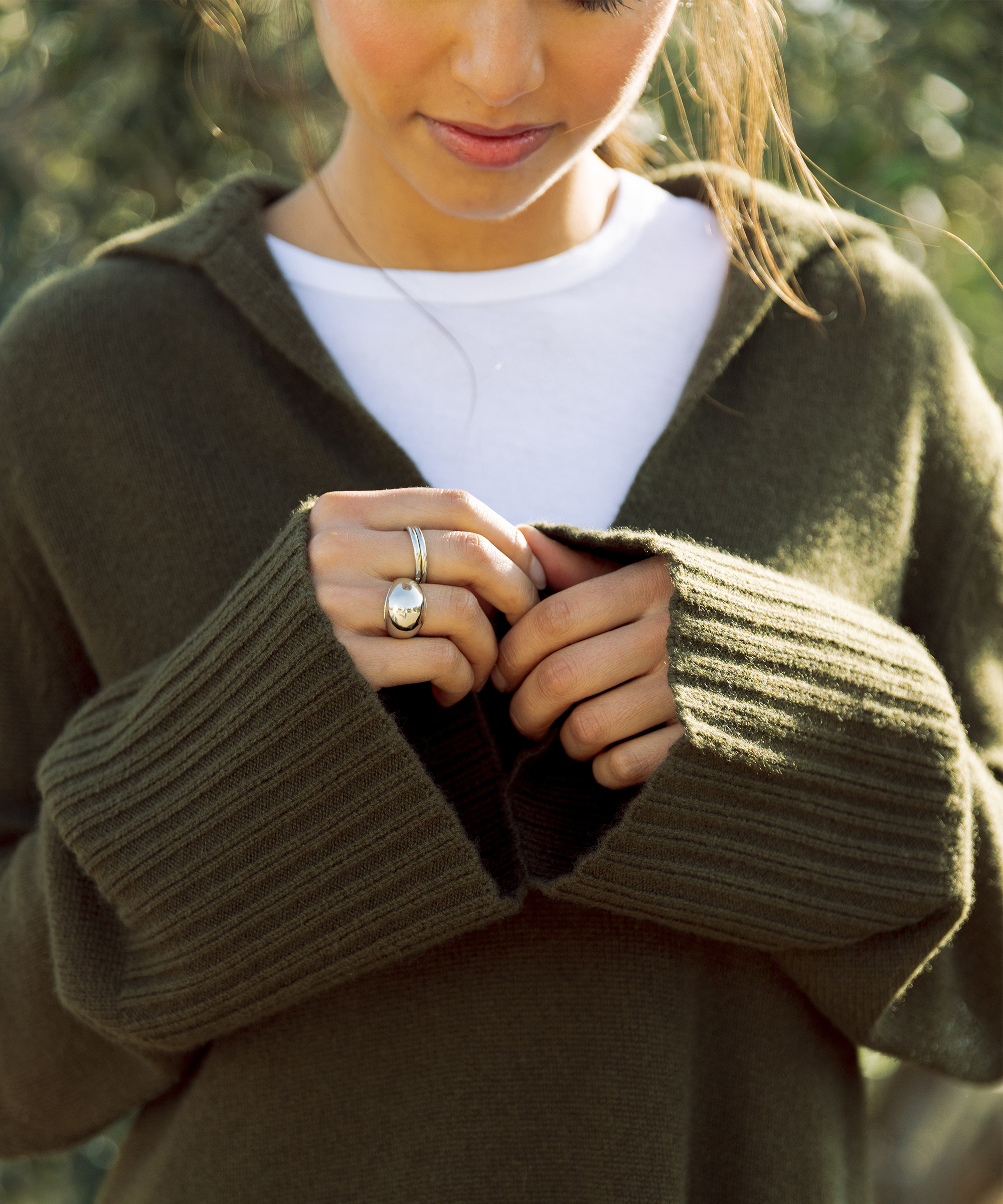 woman in an olive green cashmere frances polo with a white tee underneath