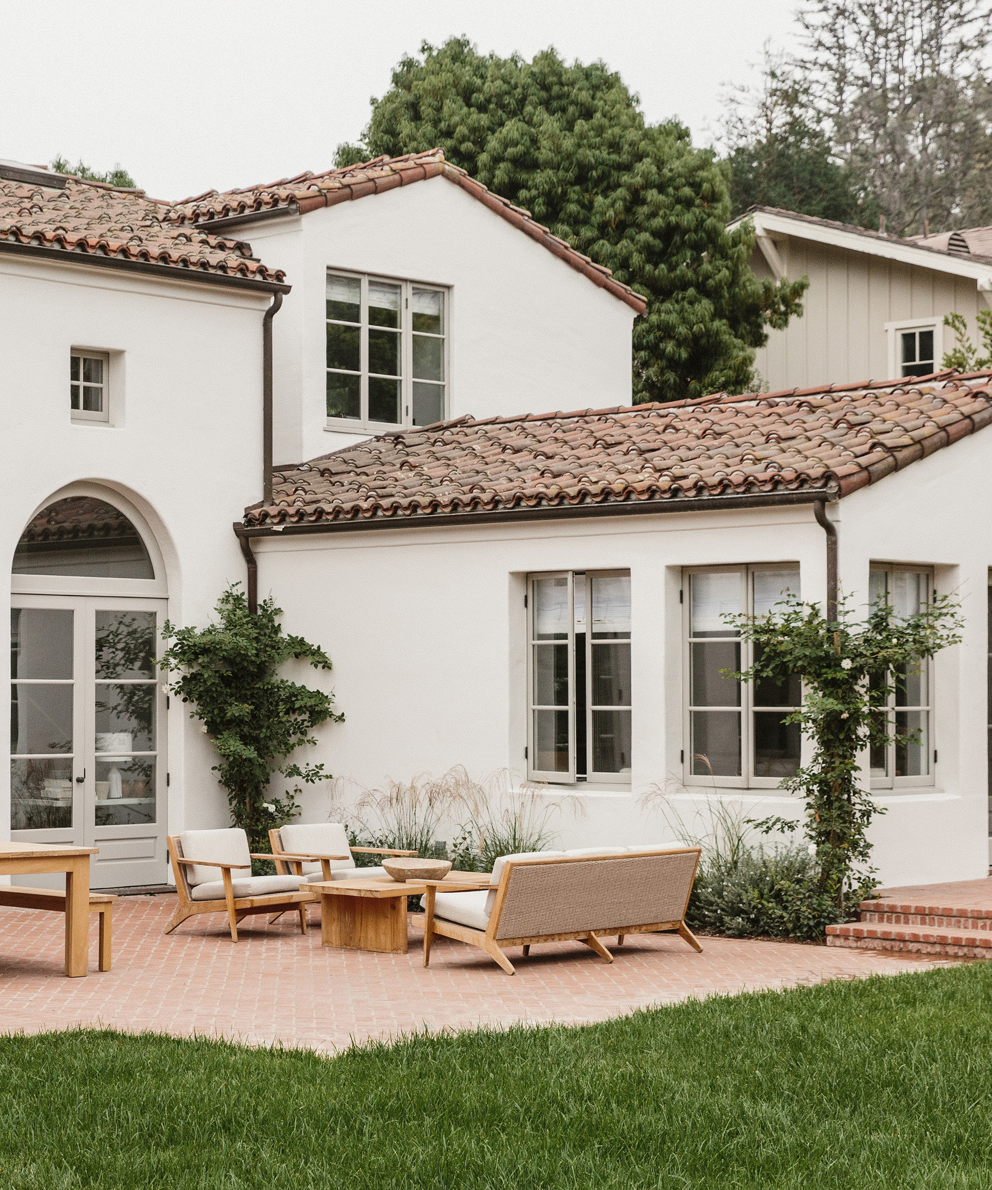 outdoor patio with back exterior of a white house and outdoor furniture