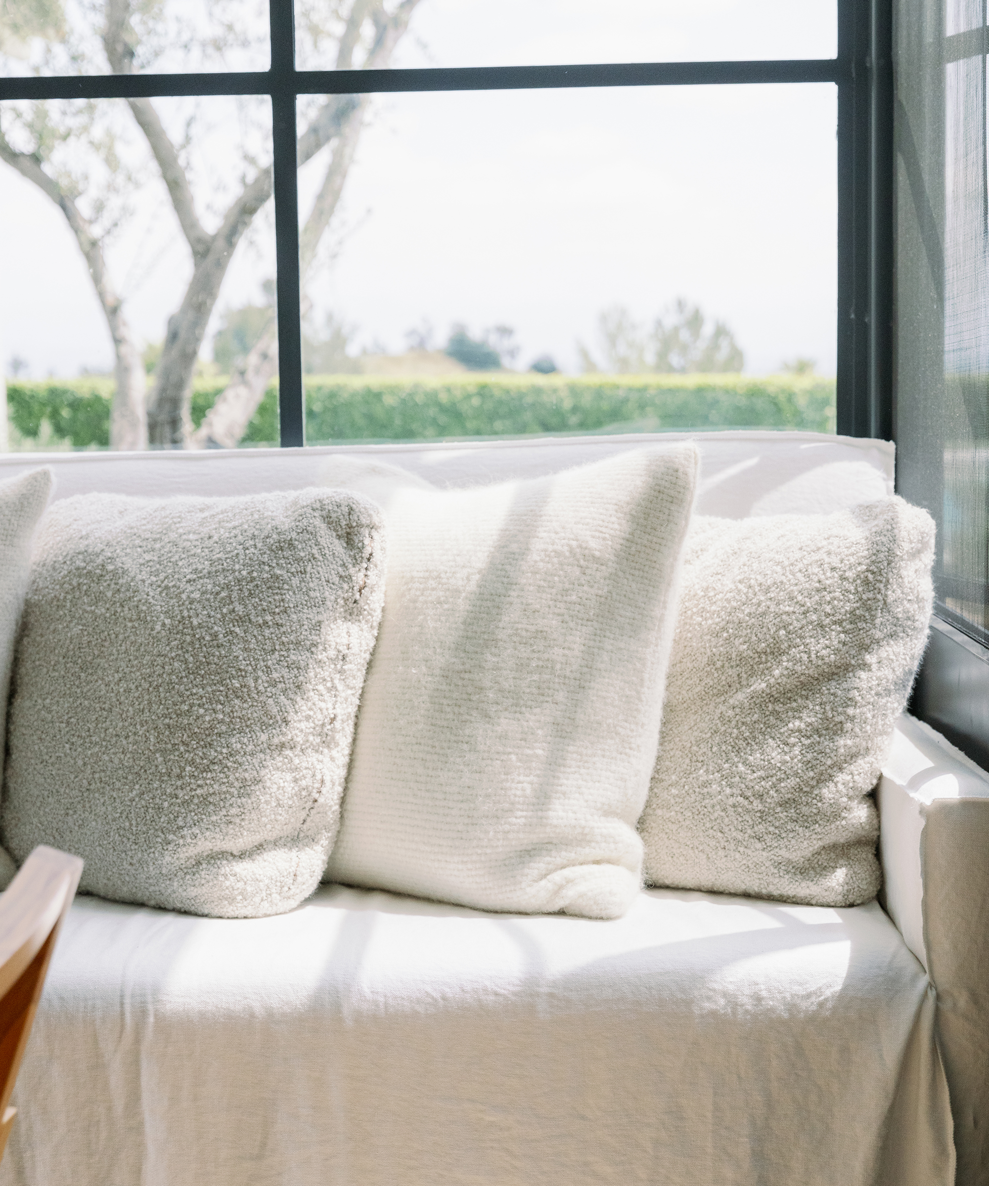 three accent pillows on a white couch