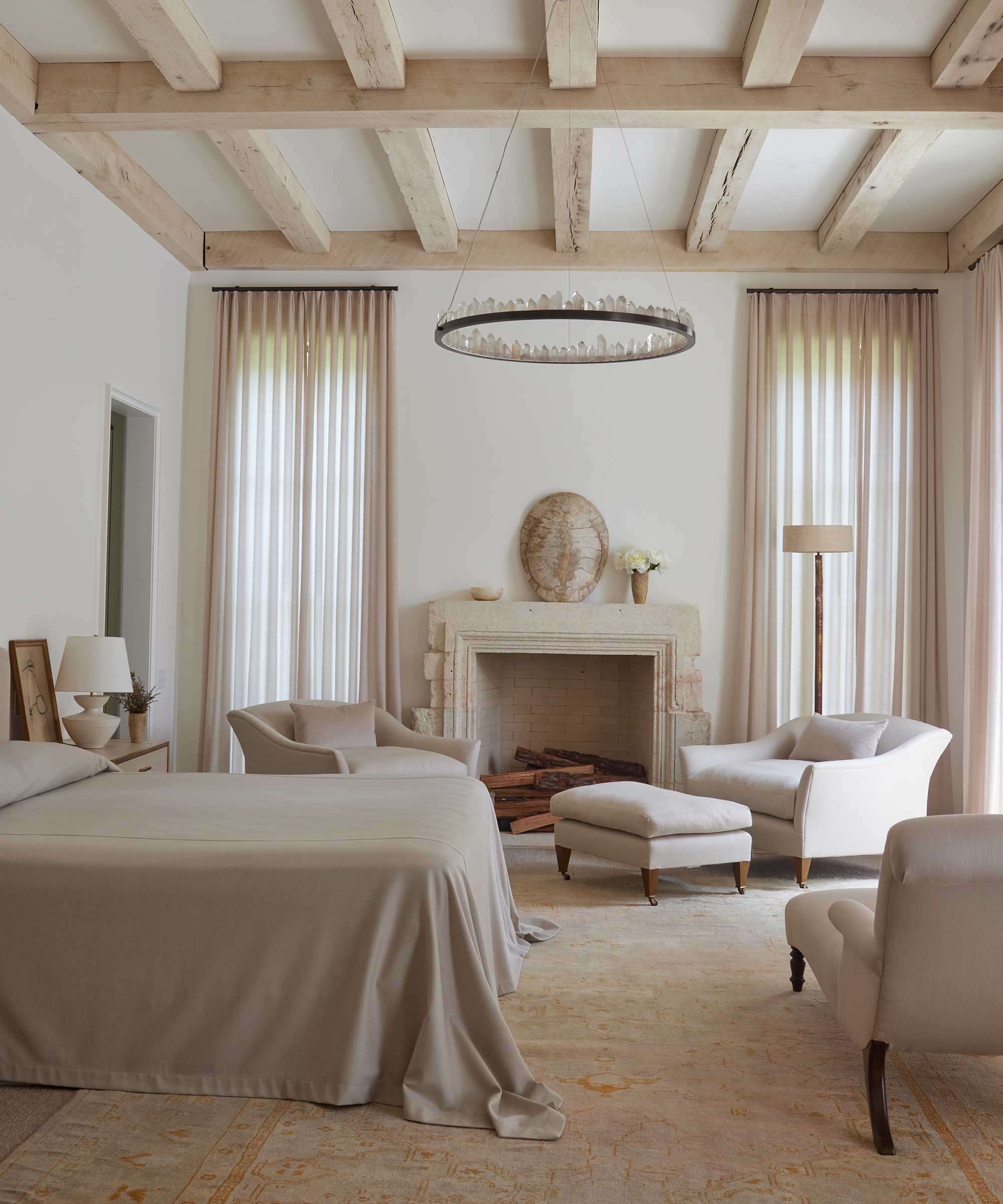 betsy-brown-home-tour-primary-bedroom-taupe-duvet-draped-large-stone-fireplace
