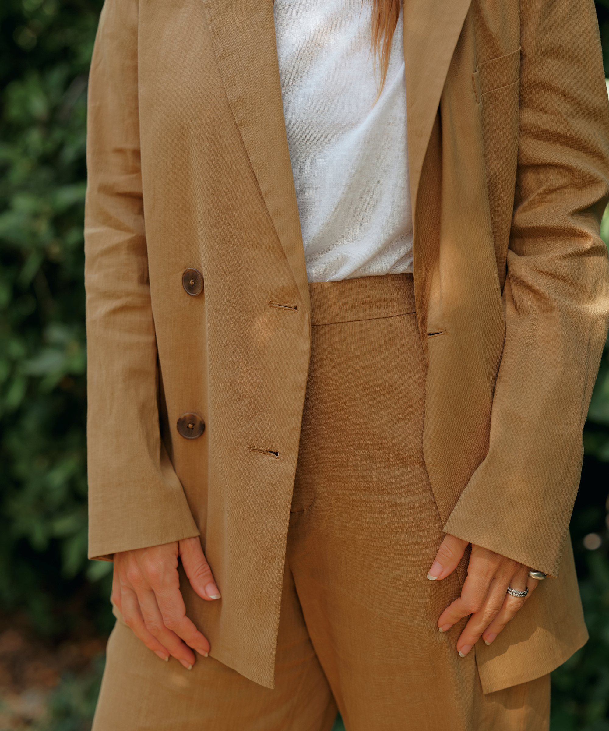 a woman wearing a taupe linen suit with a white tee