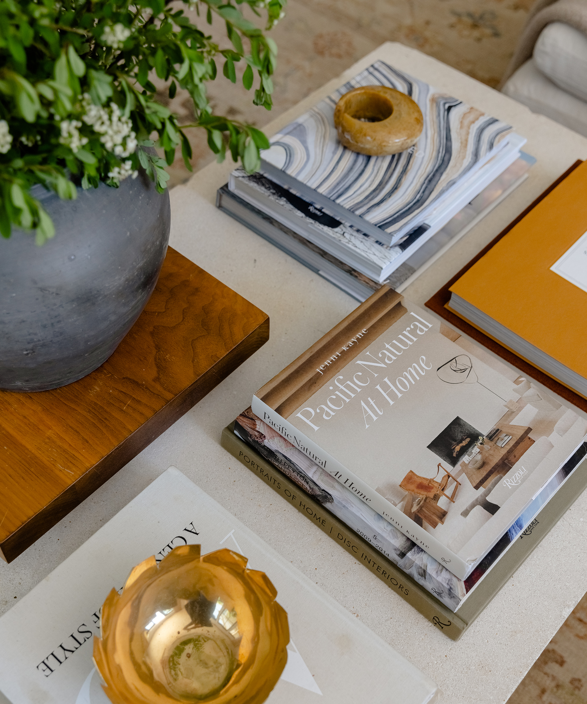 coffee table books on a marble coffee table with a black vase