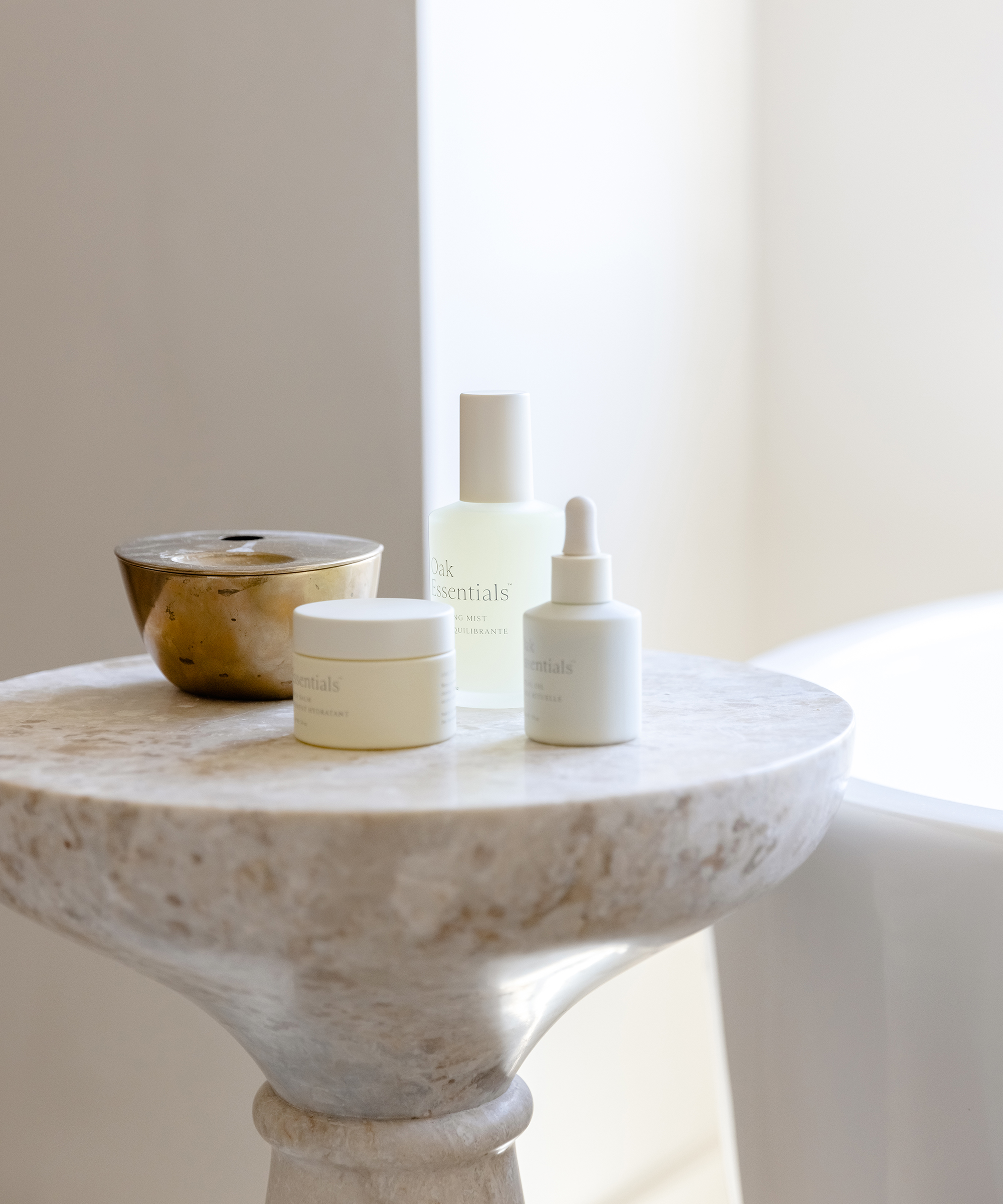 a marble side table in a bathroom with oak essentials products