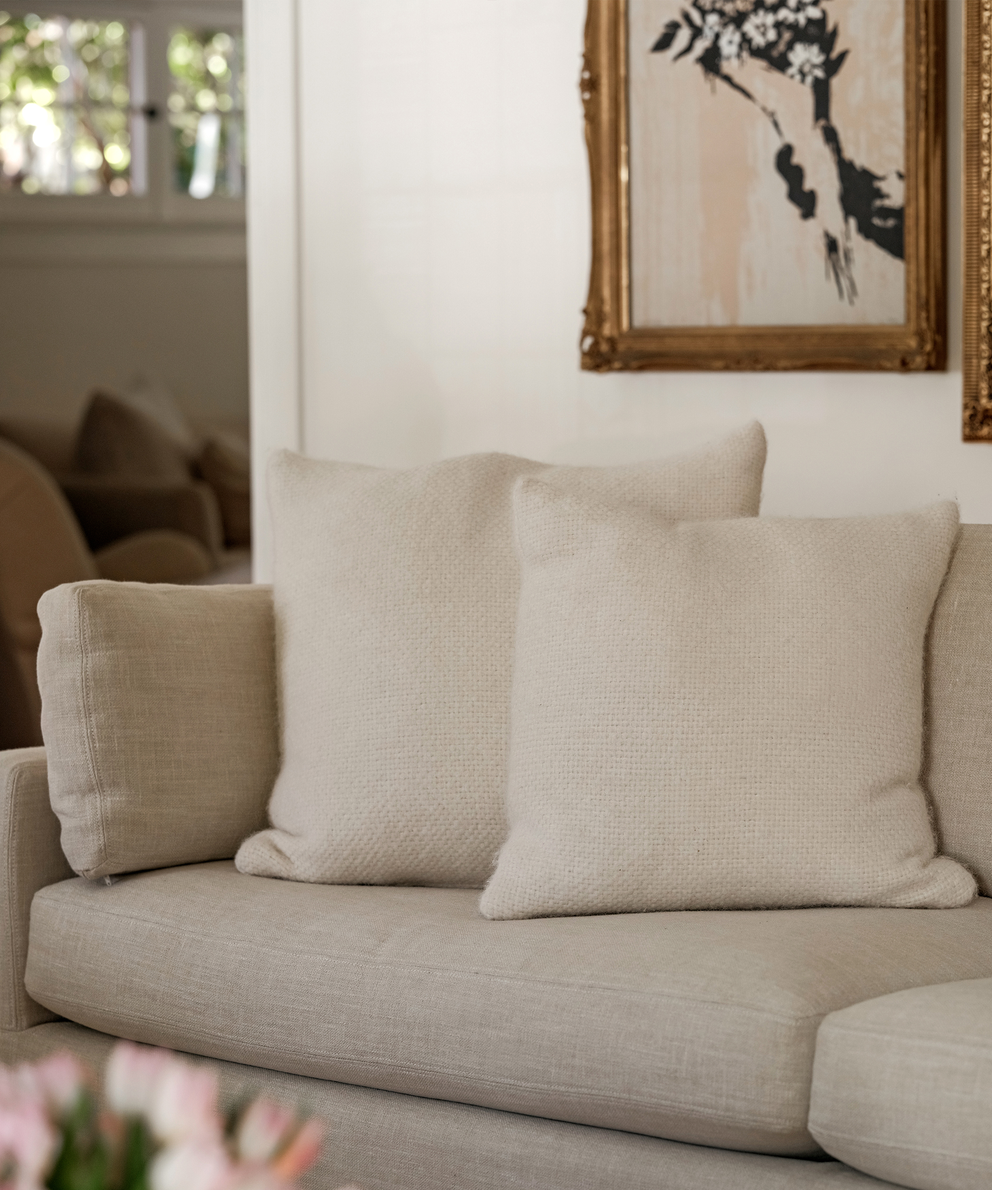 two ivory alpaca pillows on a tan linen couch