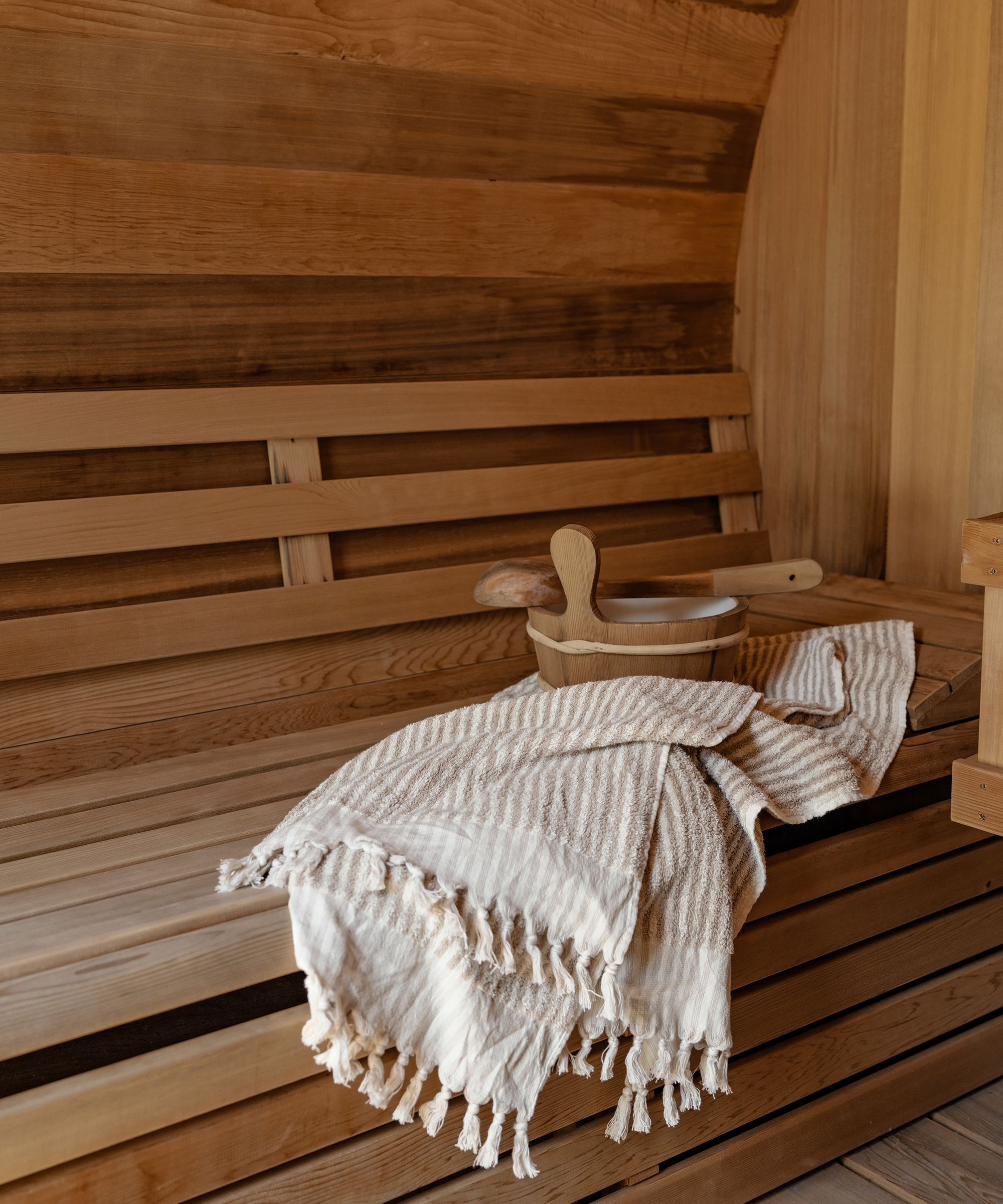 inside of a sauna with a striped beach towel hanging off