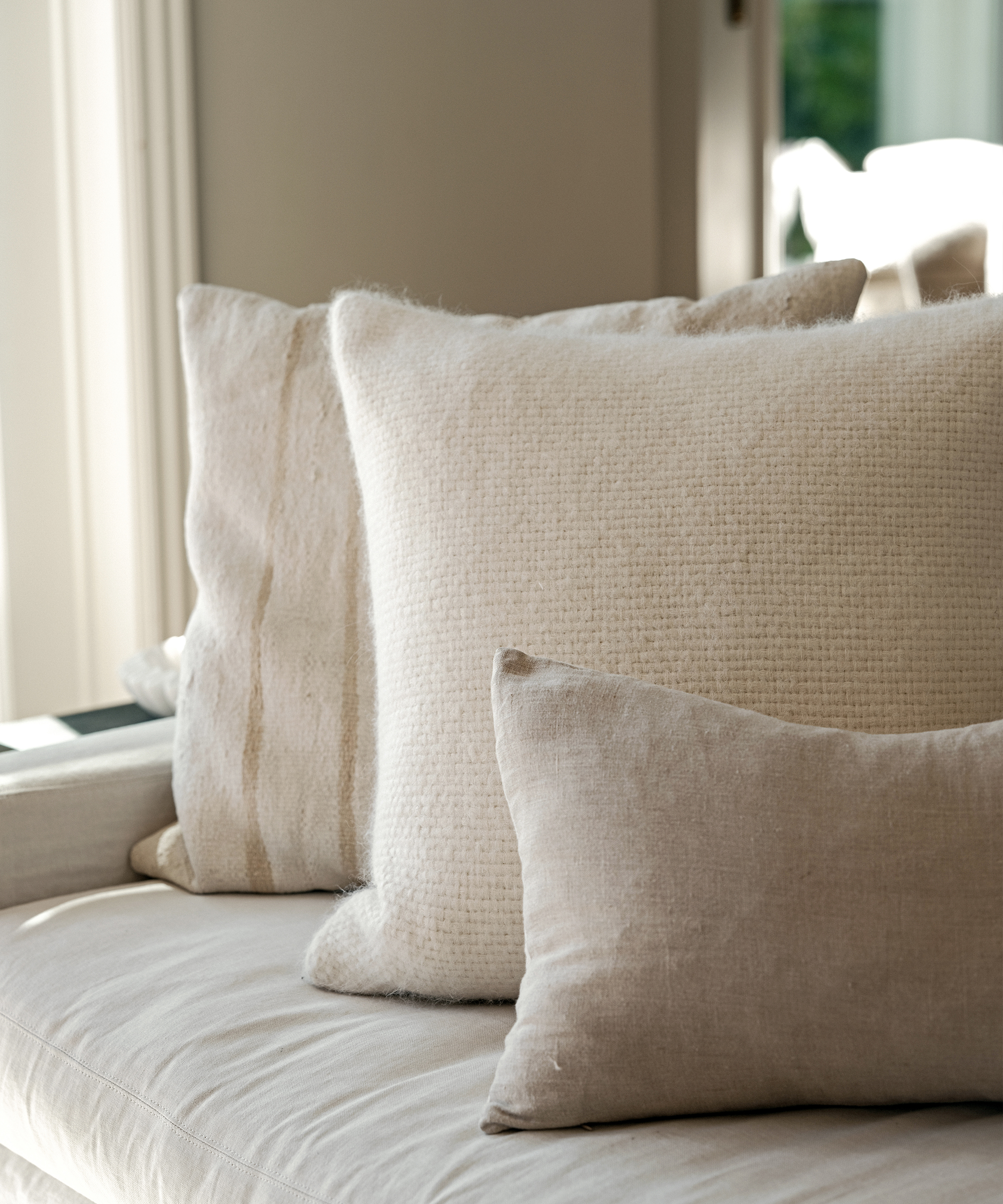 three accent pillows on a tan linen kitchen