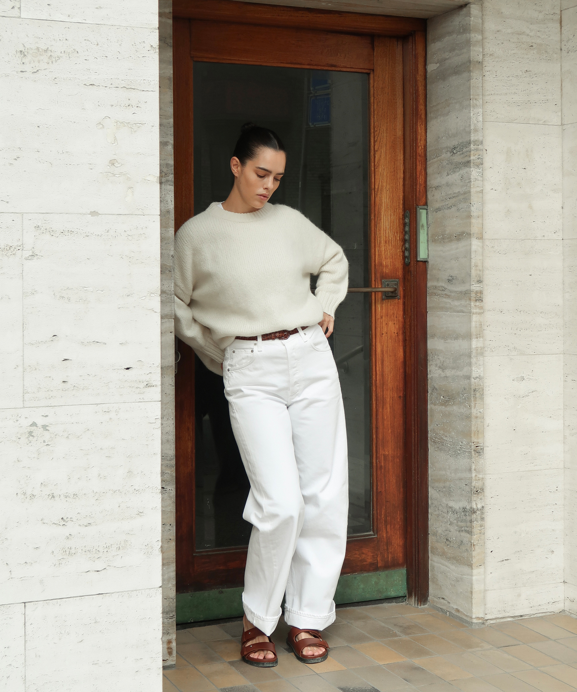 christina stougaard in a creme alpaca sweater and white jeans with tan leather sandals