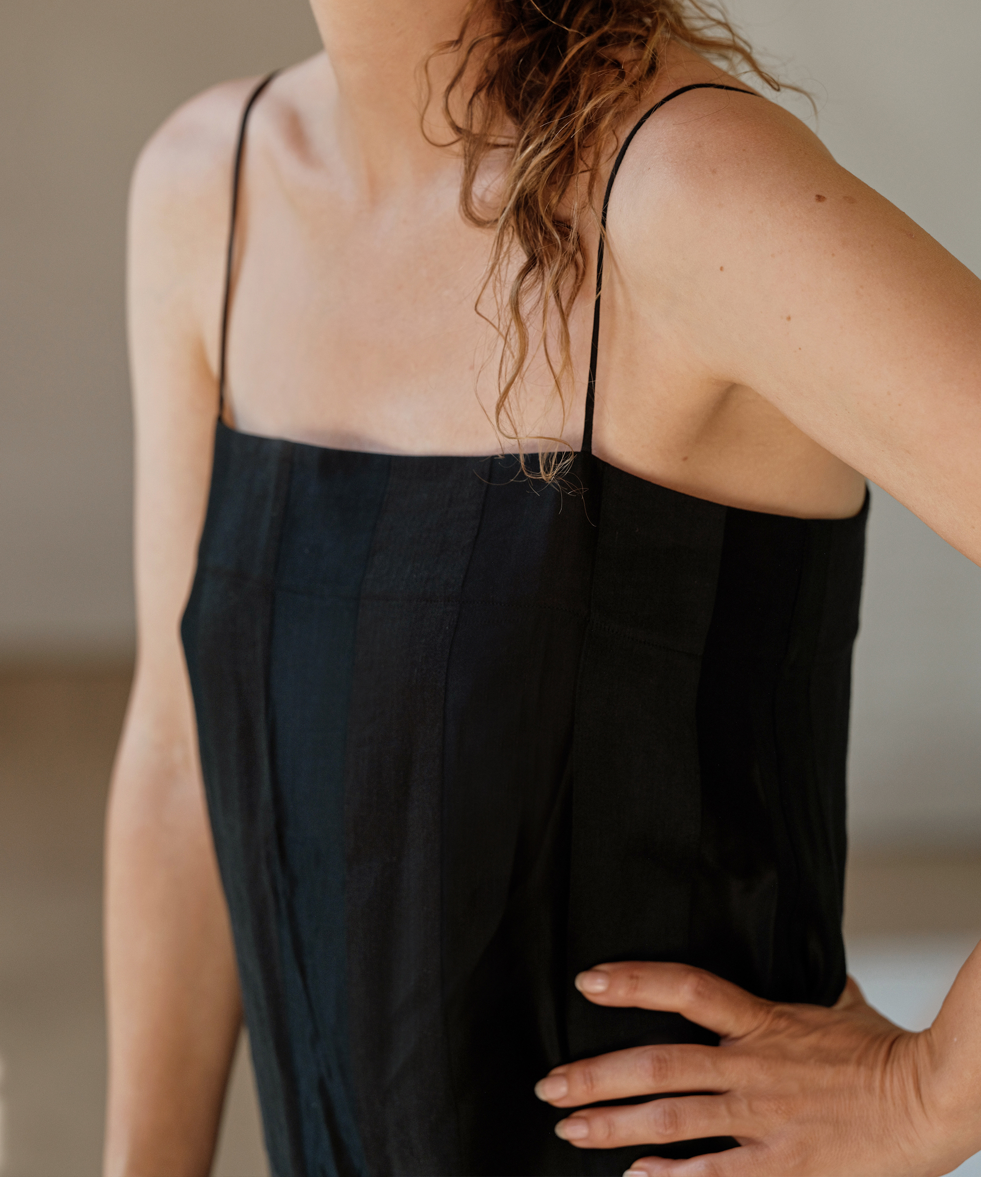 a woman wearing a black thin strap dress