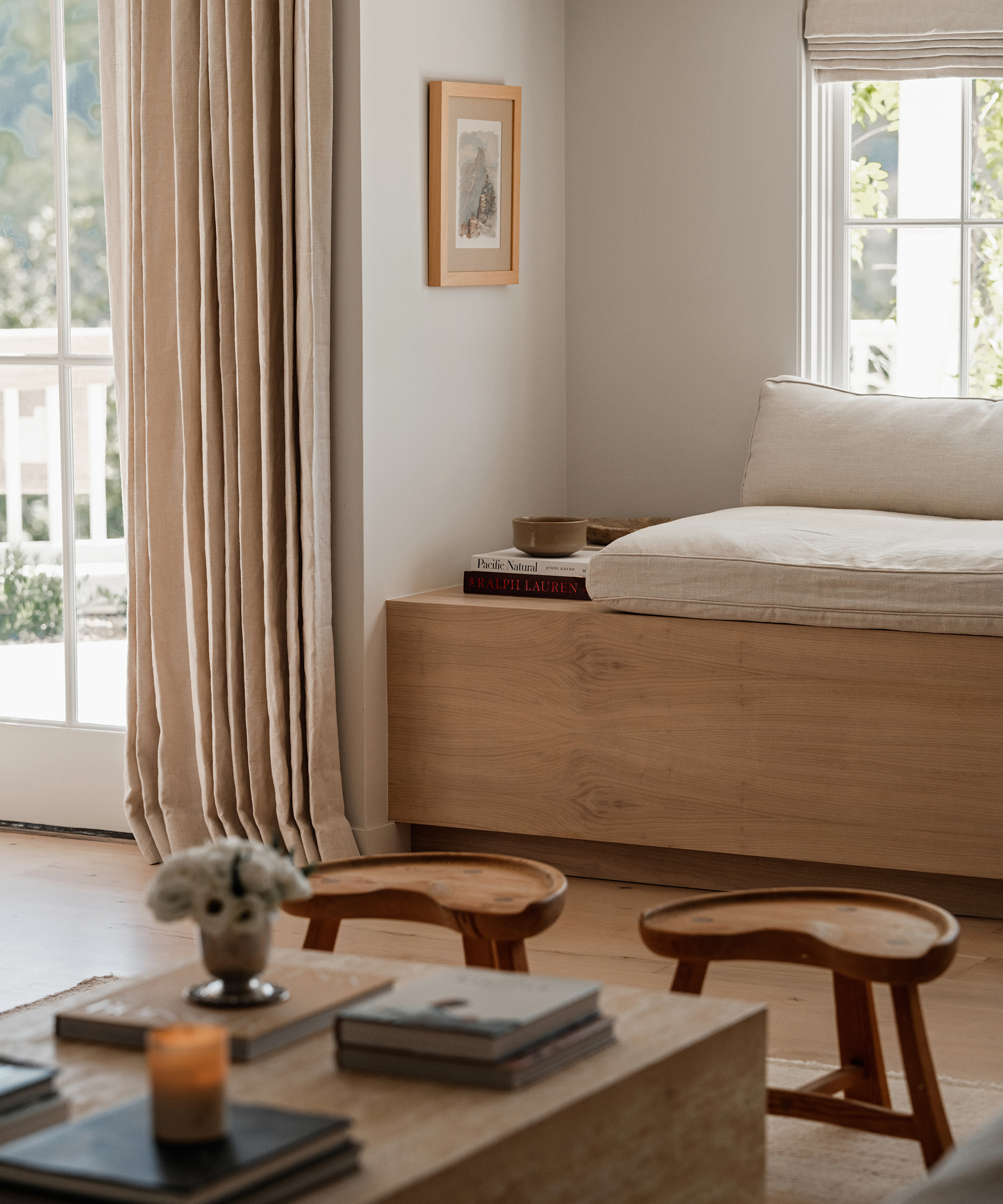 living room area with a travertine coffee table styled with coffee table books and a built in sitting nook