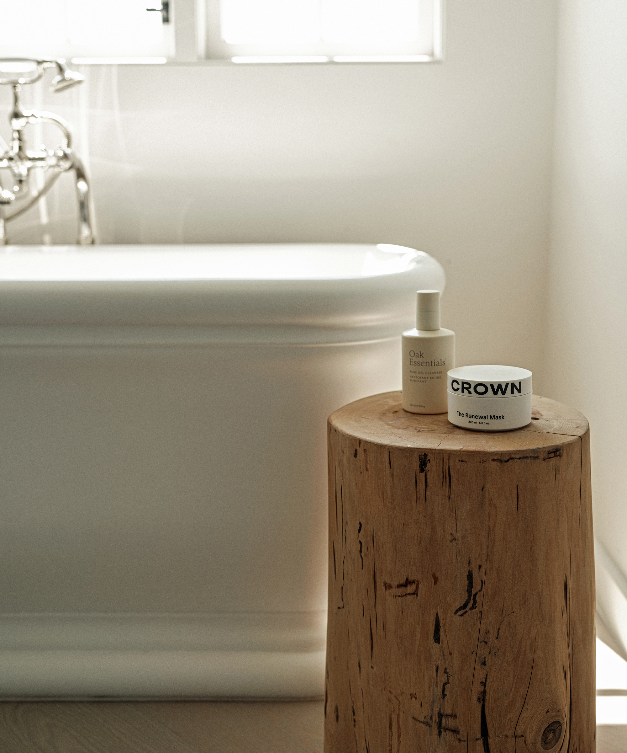 a master bathroom with a standlone tub next to a cedar stump with oak essentials products
