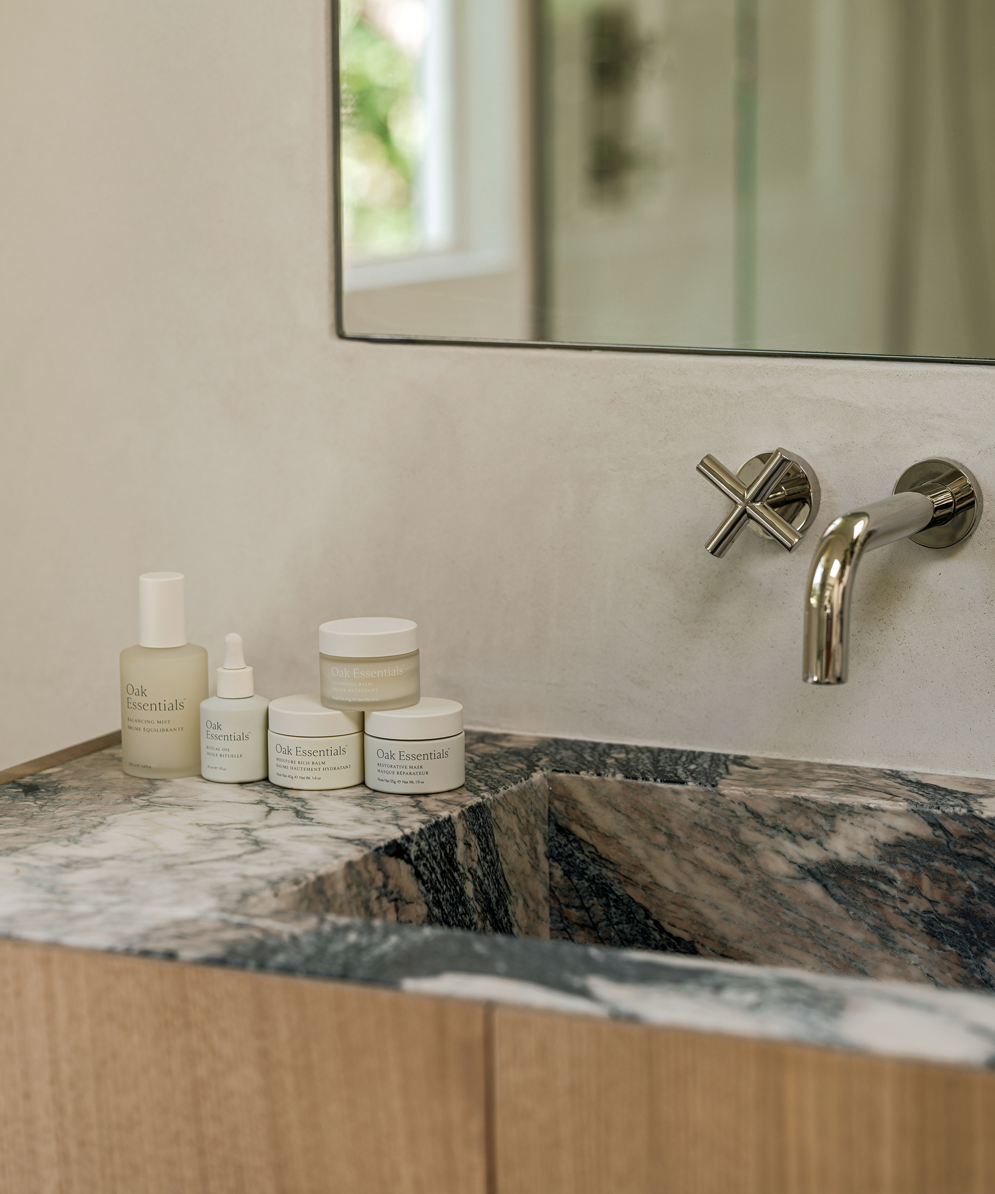 a sink vanity with oak essentials products on the counter